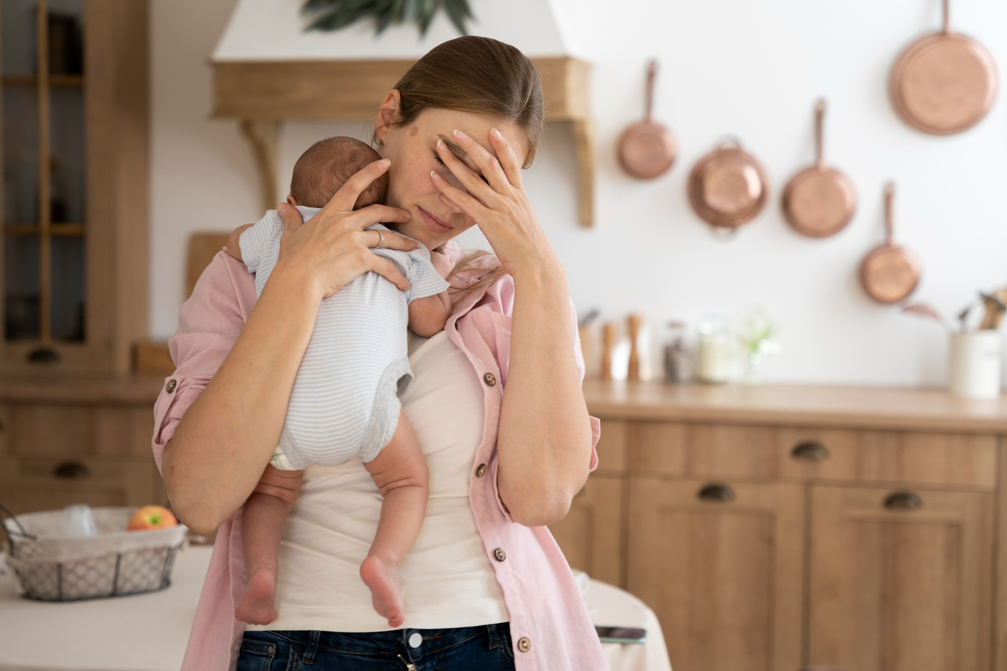 Une mère épuisée tenant un nouveau-né | Source : Freepik