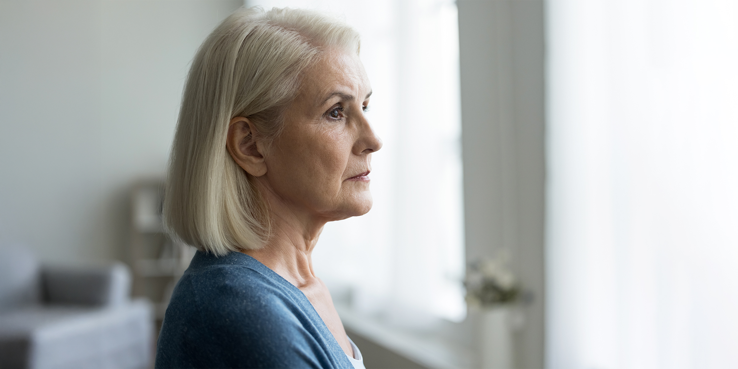 Une femme tendue qui regarde par la fenêtre | Source : Shutterstock