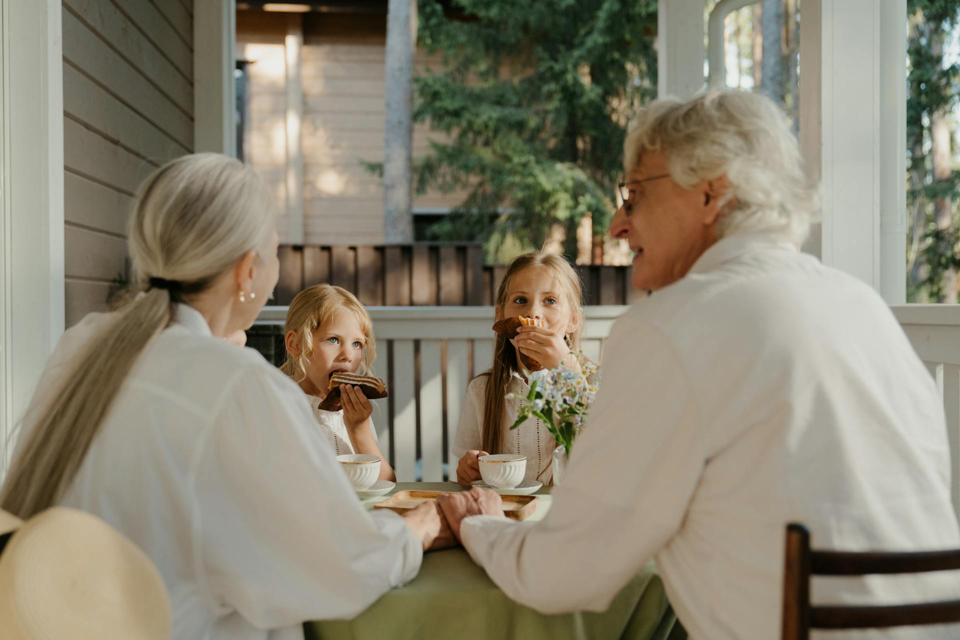 Un couple âgé mangeant avec deux enfants | Source : Pexels