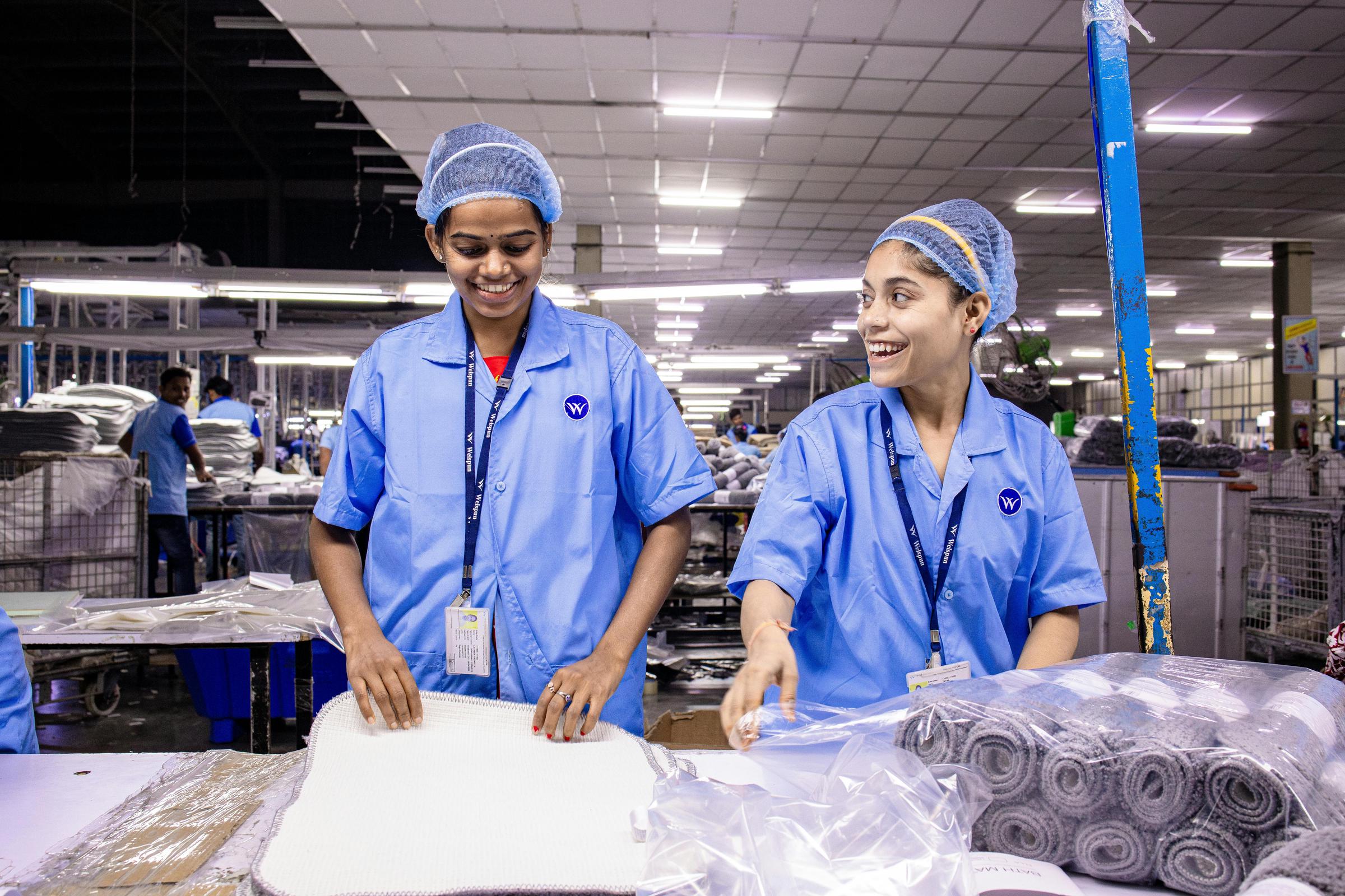 Des employés heureux travaillant dans un entrepôt de textile | Source : Pexels