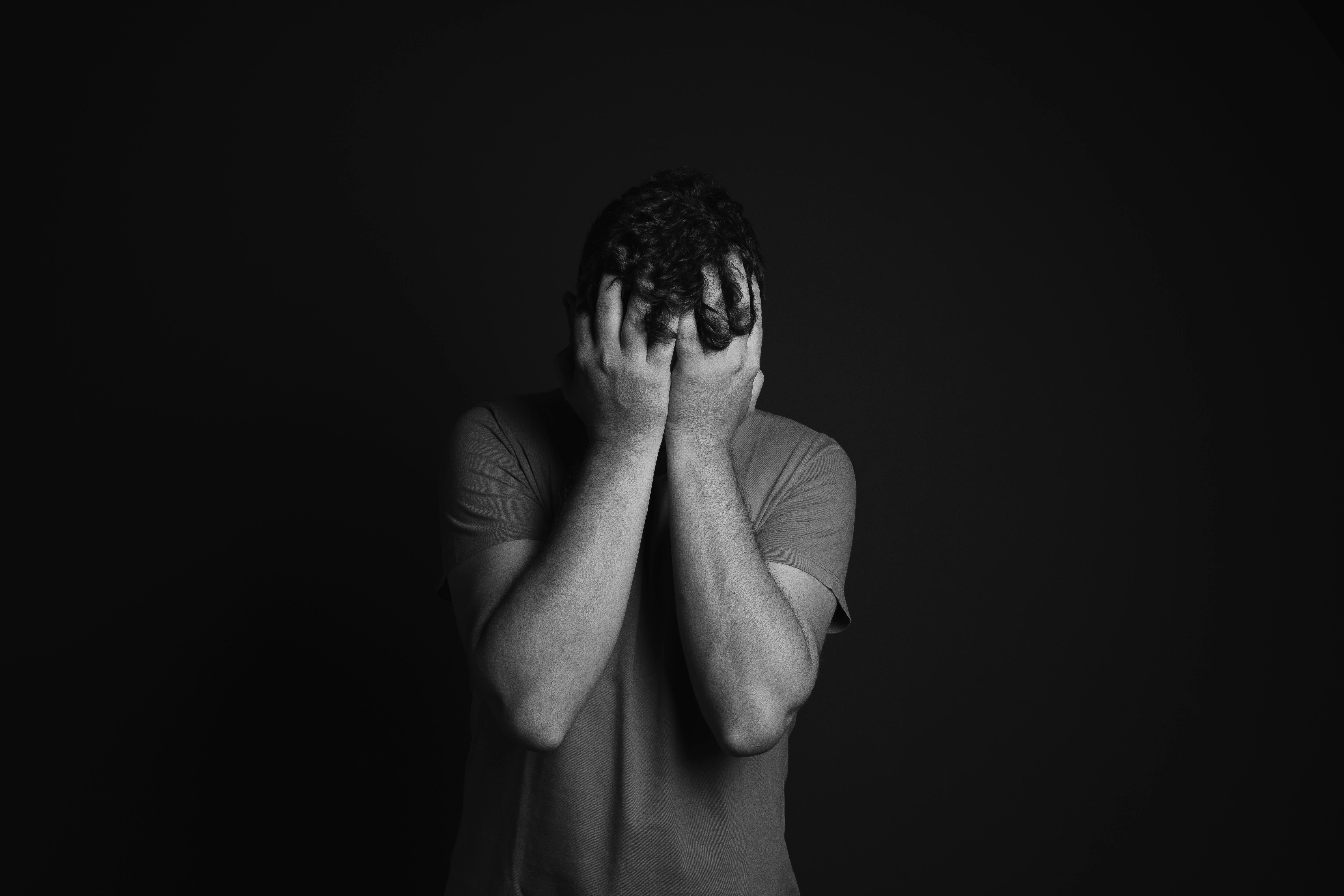 Un homme triste qui se couvre le visage | Source : Pexels