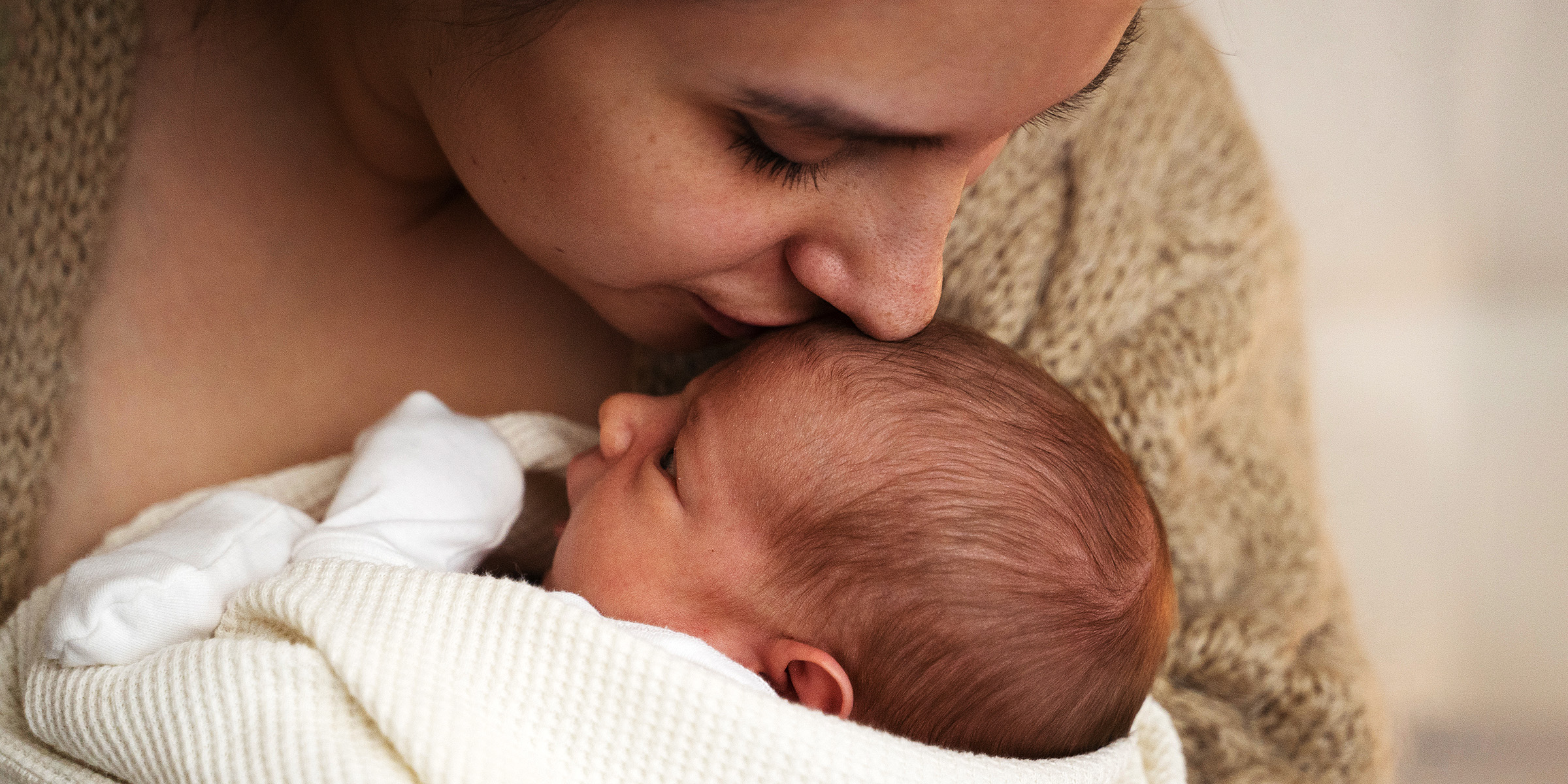 Une femme embrasse son bébé | Source : Freepik