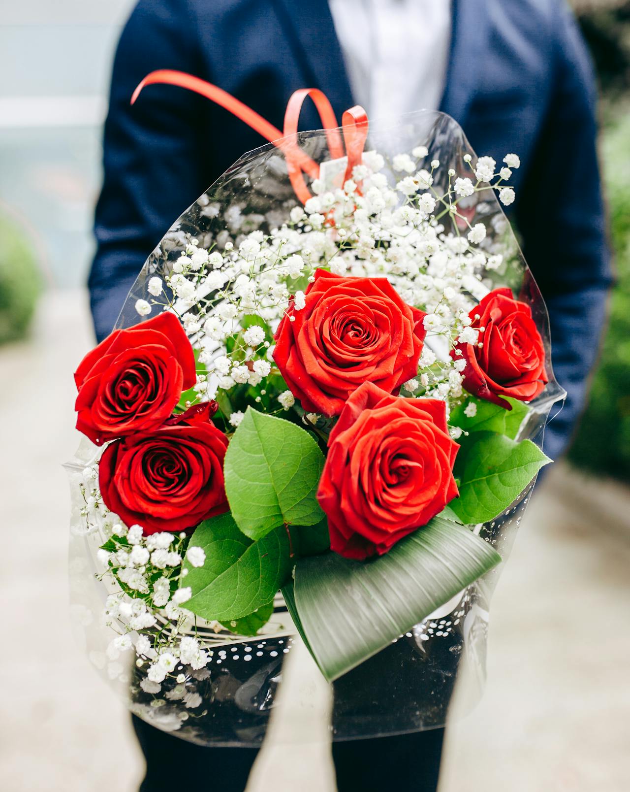 Un homme tenant un bouquet de fleurs | Source : Pexels