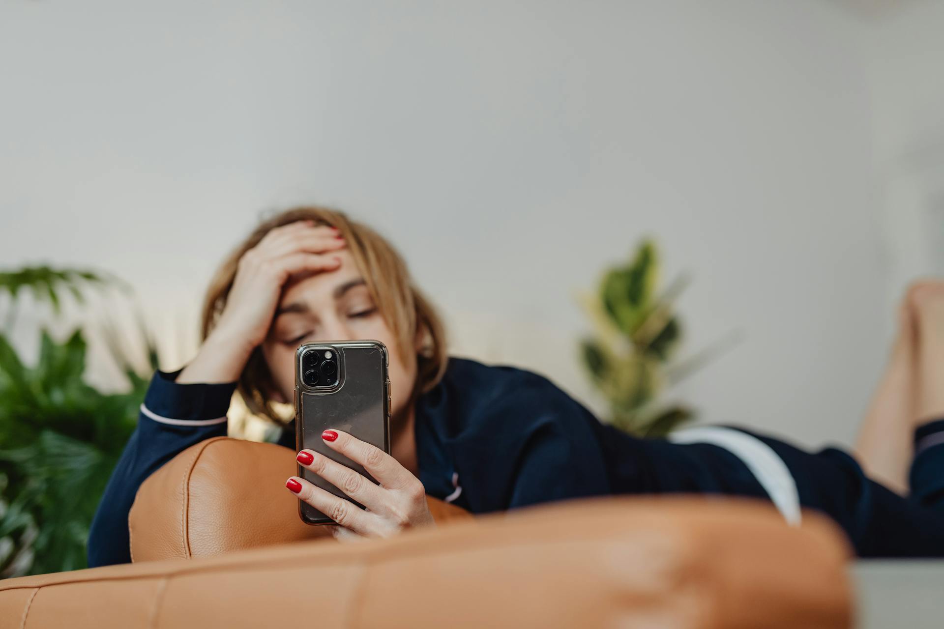 Une femme allongée tout en regardant son téléphone | Source : Pexels