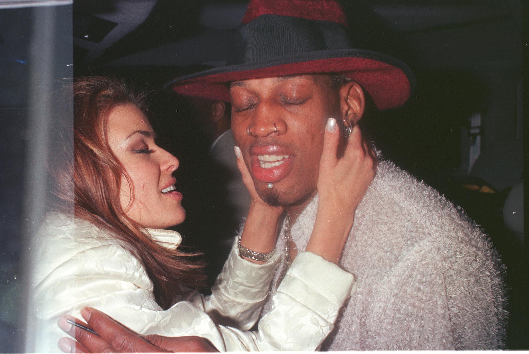 Carmen Electra caresse le visage de Dennis Rodman lors d'un moment intime pendant une soirée à Beverly Hills en 1999. Le couple s'est marié impulsivement cette année-là, mais s'est séparé un peu plus d'une semaine plus tard.