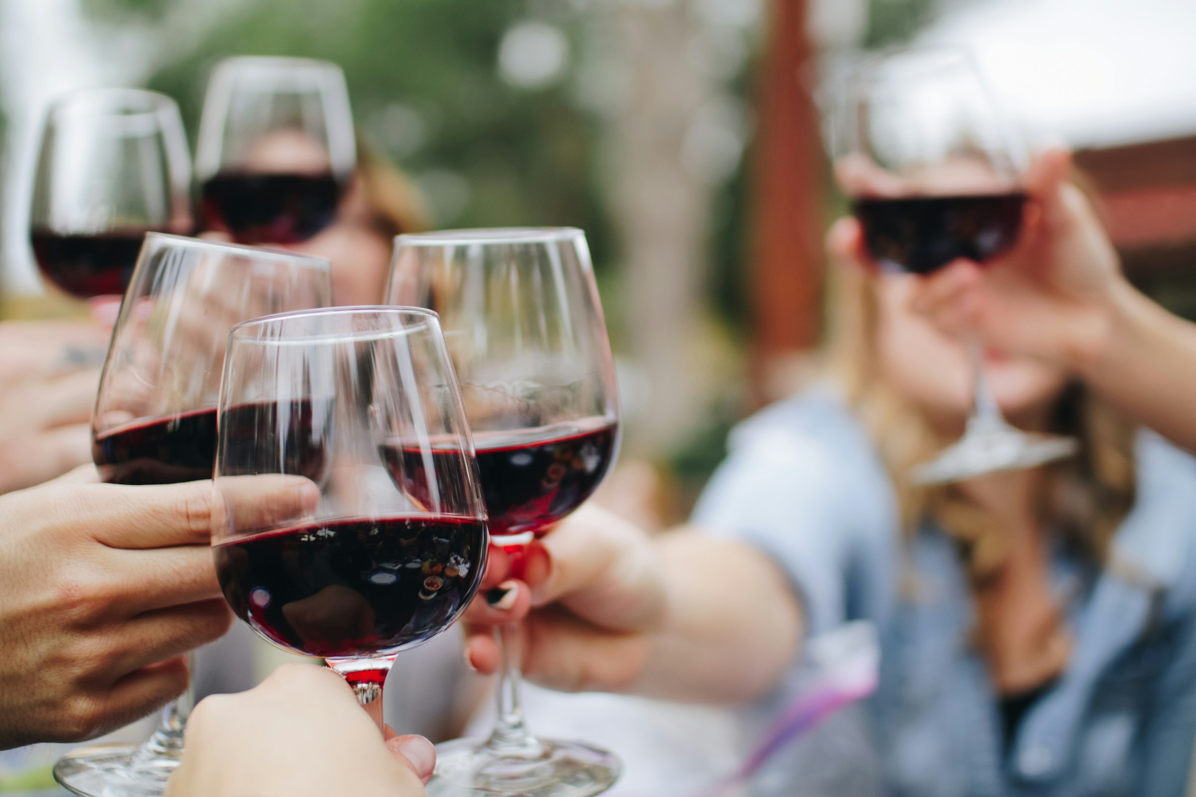 Des personnes tenant des verres de vin | Source : Unsplash