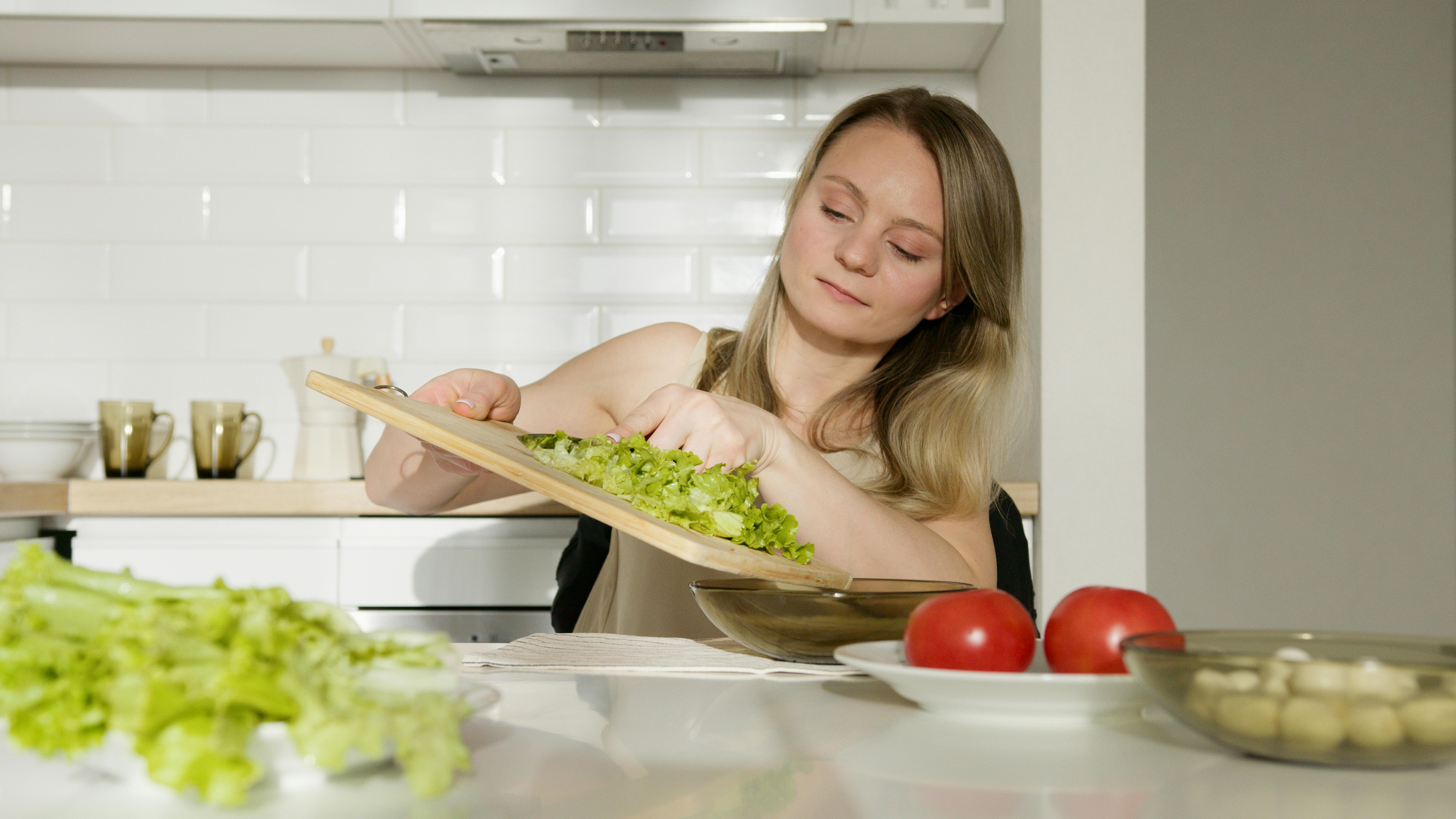 Jeune femme préparant une salade | Source : Pexels