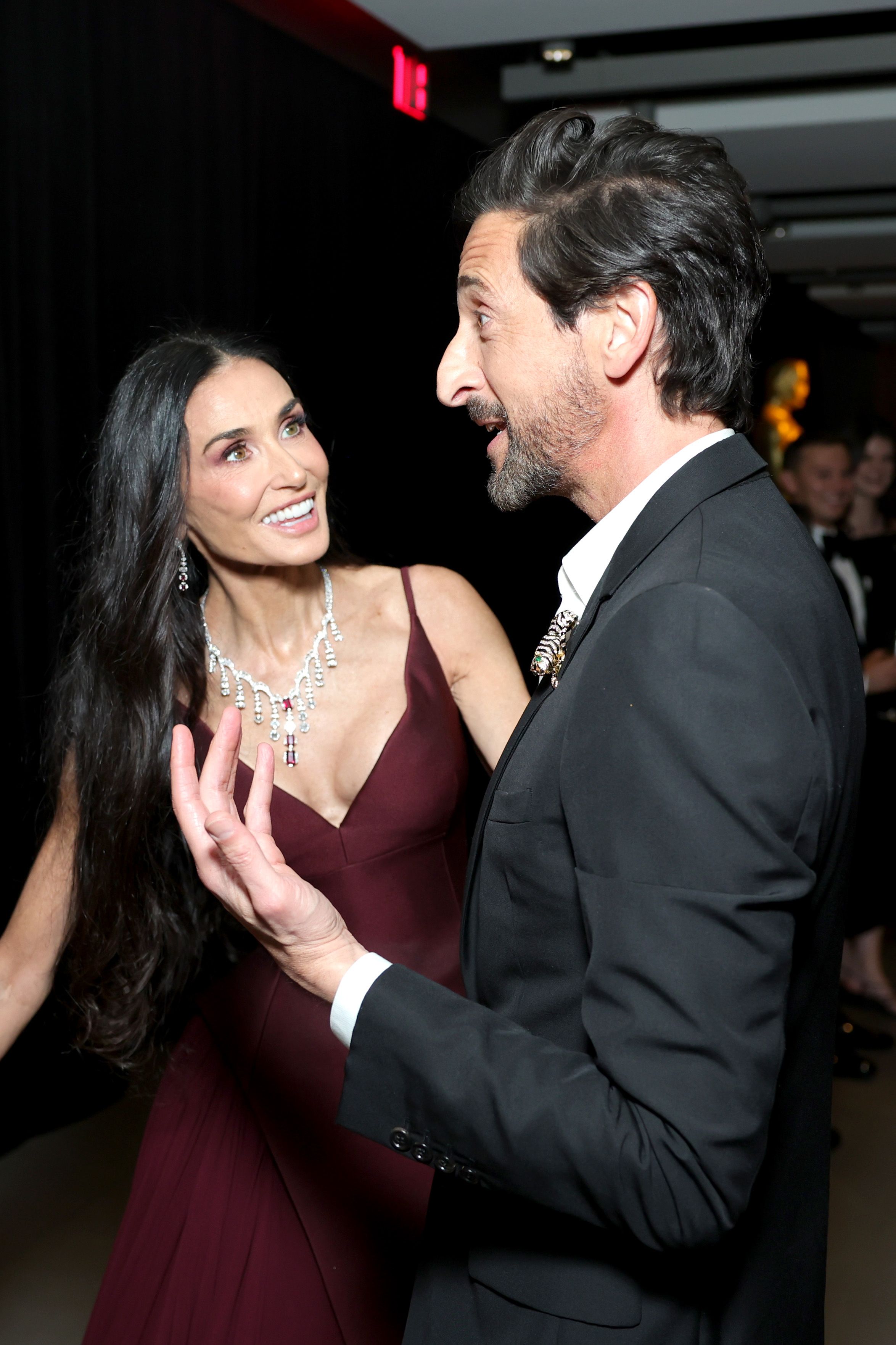Rayonnante et animée, Demi Moore échange quelques mots en toute décontraction avec Adrien Brody, son langage corporel ouvert et expressif alors que les deux acteurs se penchent l'un vers l'autre lors d'un moment animé du gala.