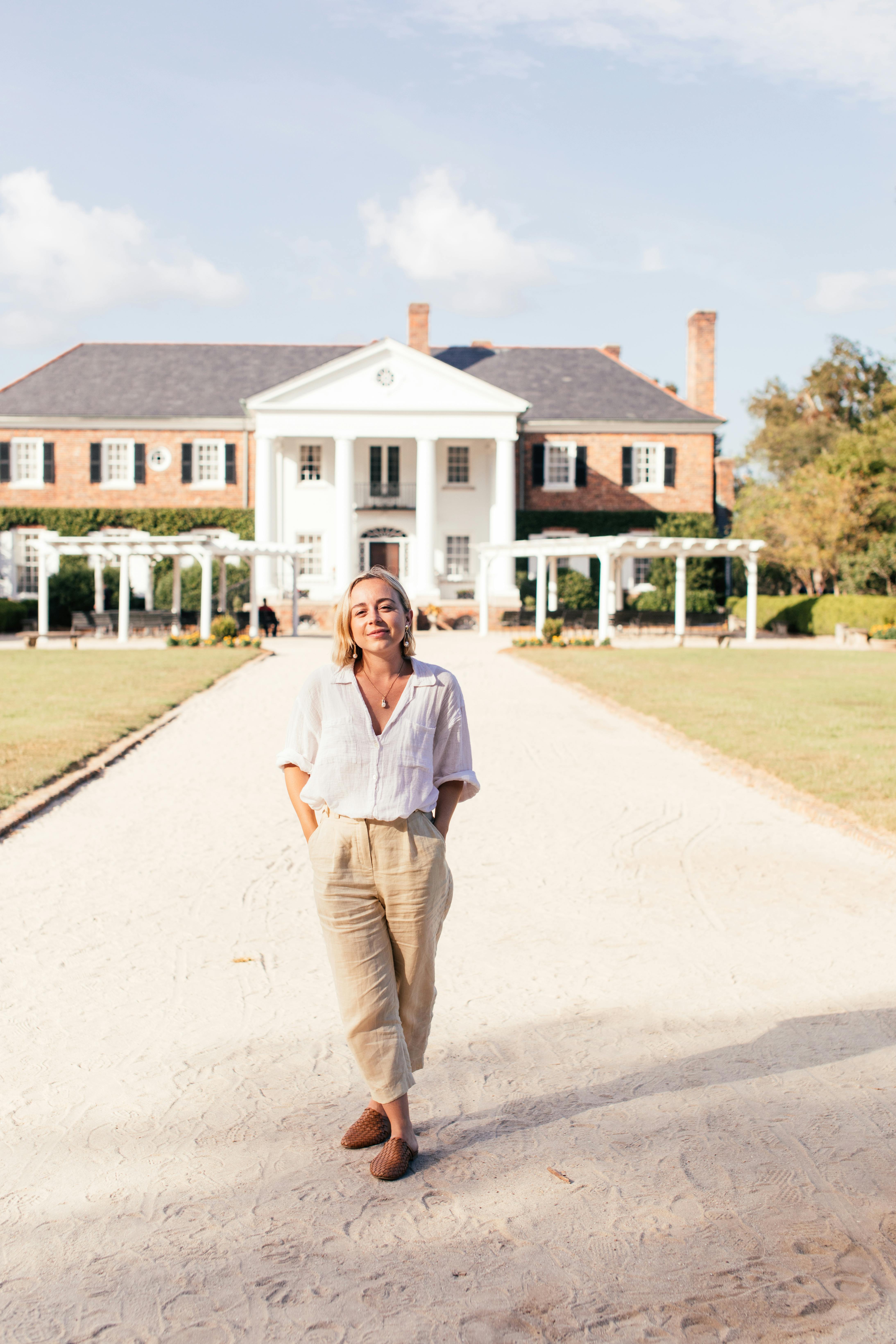 Une femme heureuse se tenant devant un manoir | Source : Pexels