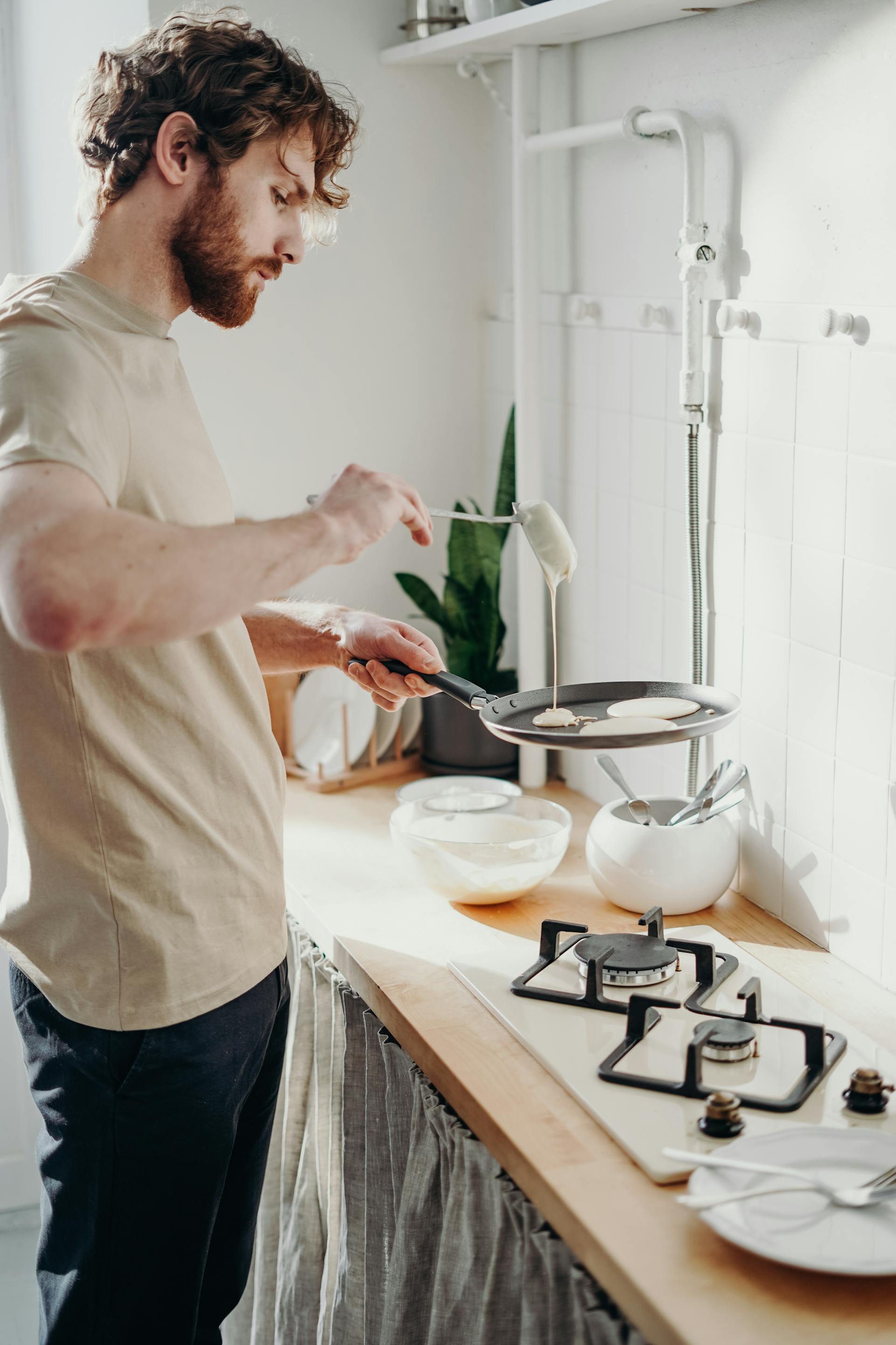Un homme qui fait des crêpes dans la cuisine | Source : Pexels