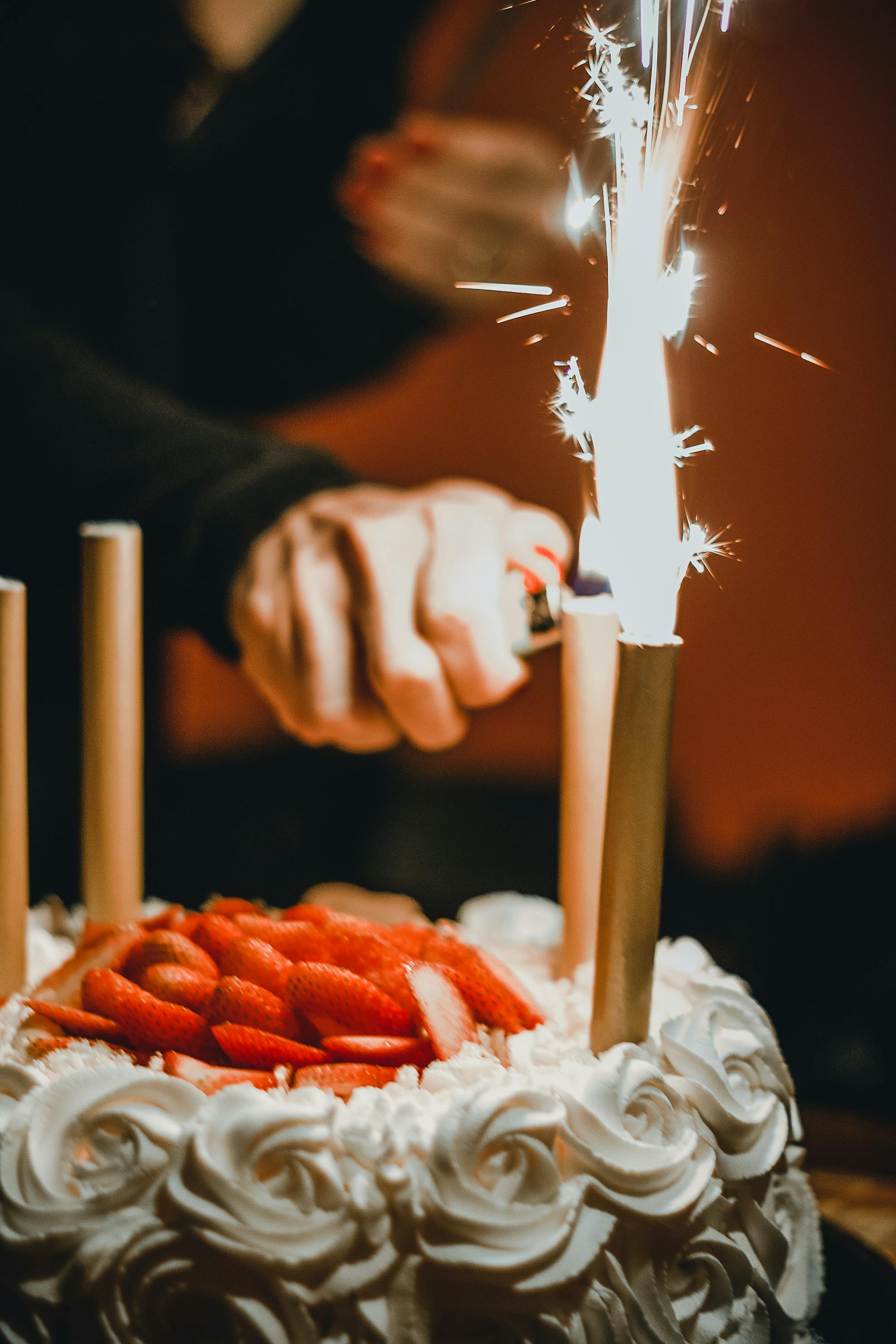 Une femme qui allume les bougies d'un gâteau d'anniversaire | Source : Pexels