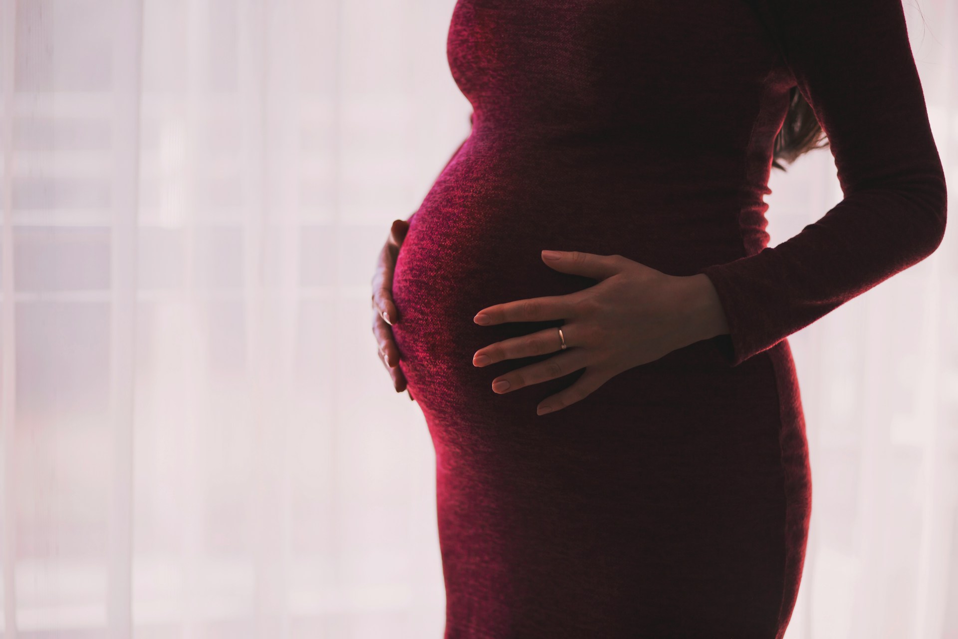 Une femme enceinte qui tient son baby bump | Source : Unsplash