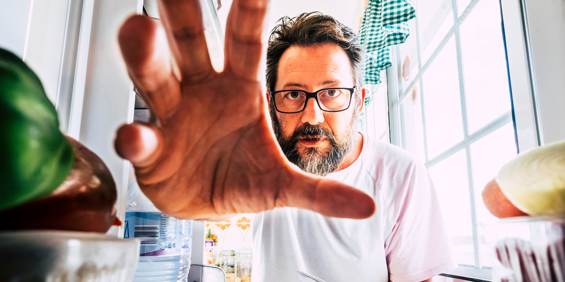 Homme saisissant de la nourriture dans le réfrigérateur | Source : Shutterstock