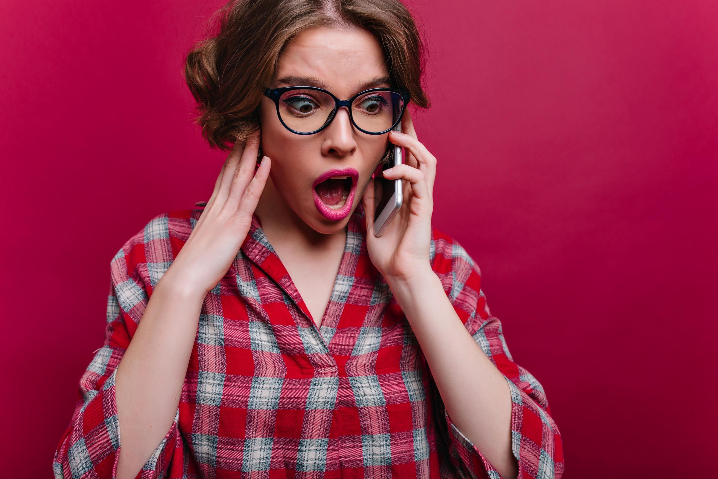 Une femme choquée lors d'un appel | Source : Freepik