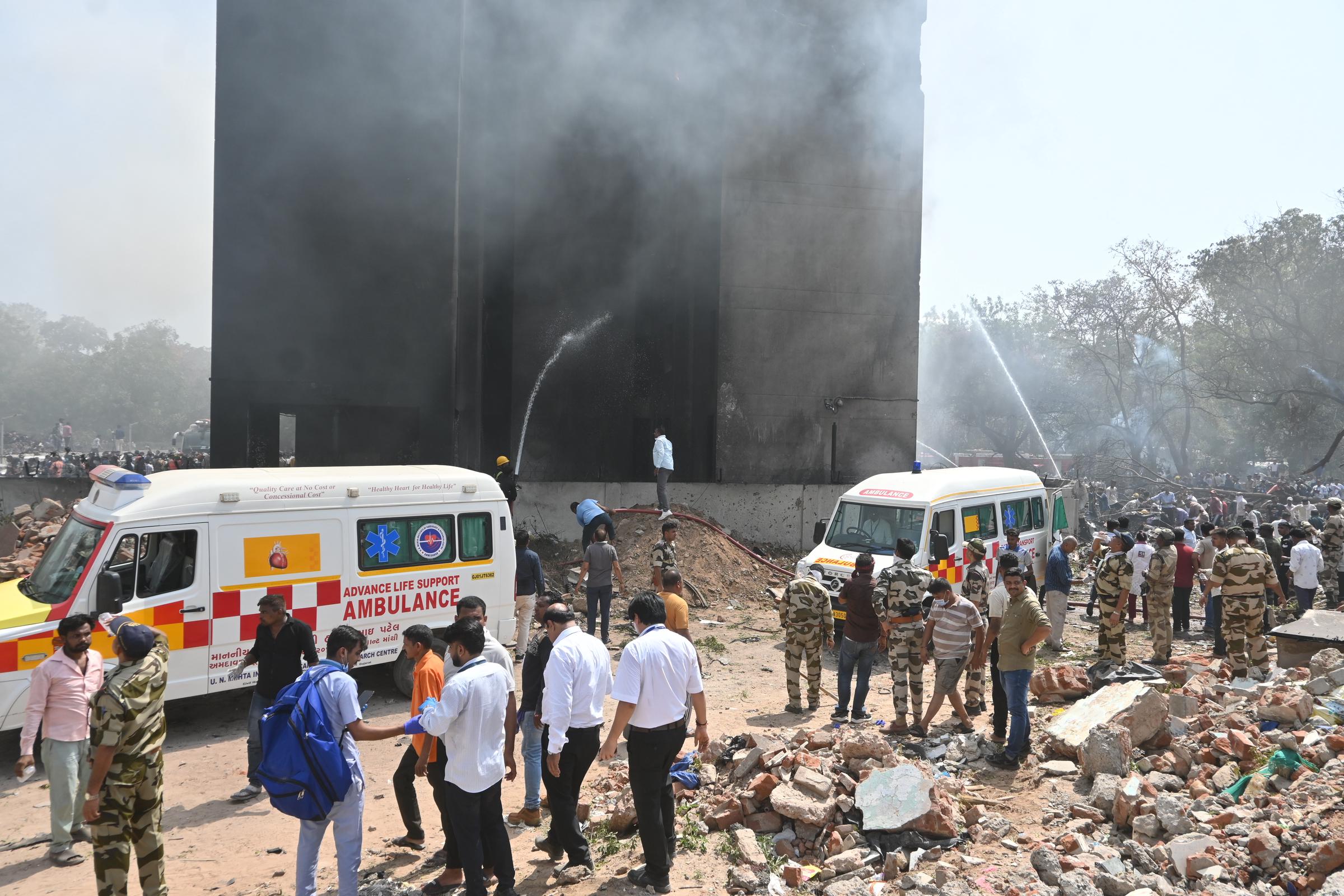 Les secouristes nettoient au jet d'eau un bâtiment enfumé alors que les équipes d'urgence et les ambulances se rassemblent sur le site de l'accident à Ahmedabad le 12 juin 2025 | Source : Getty Images