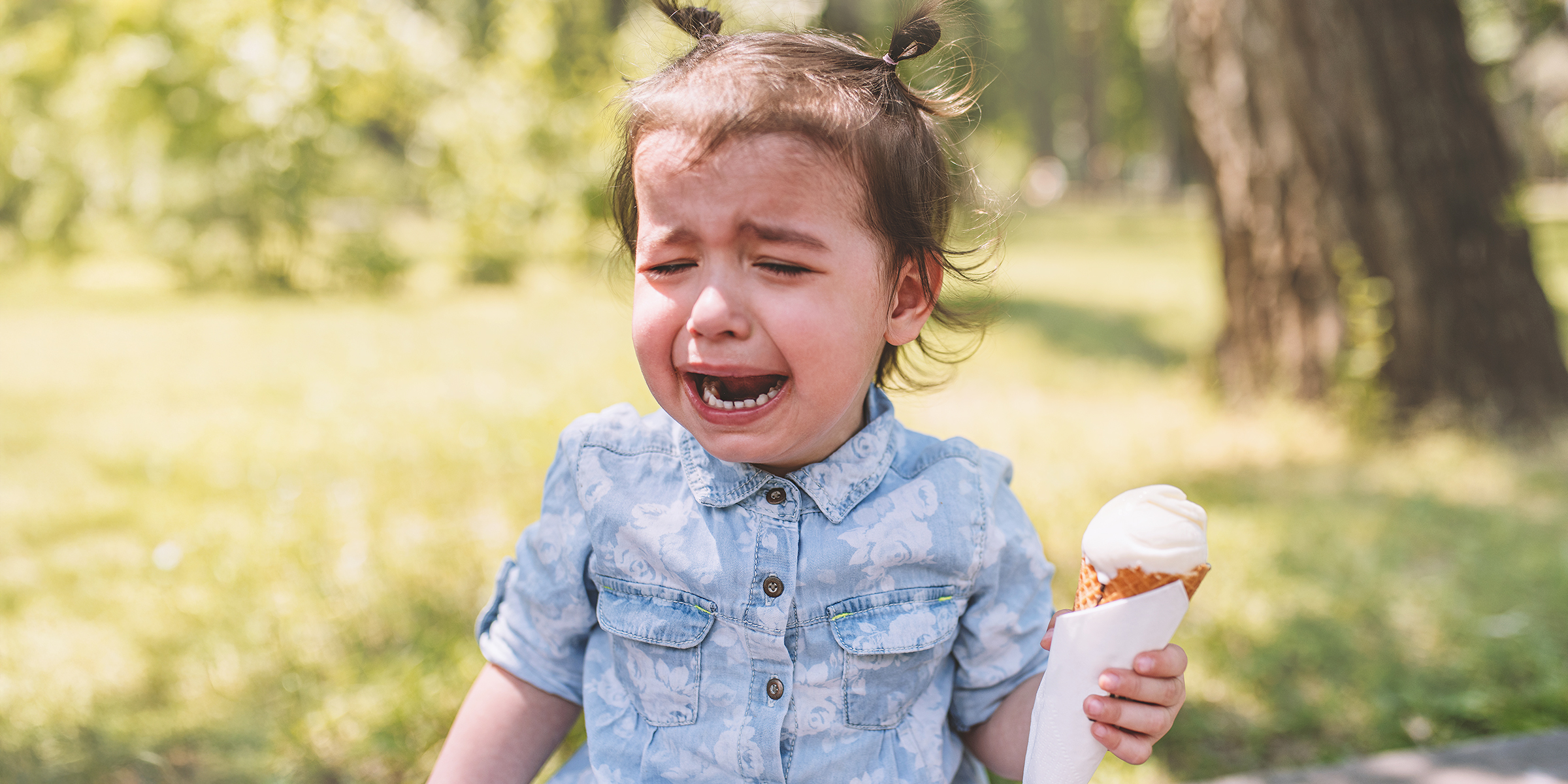 Une petite fille en pleurs tenant un cornet de glace | Source : Shutterstock