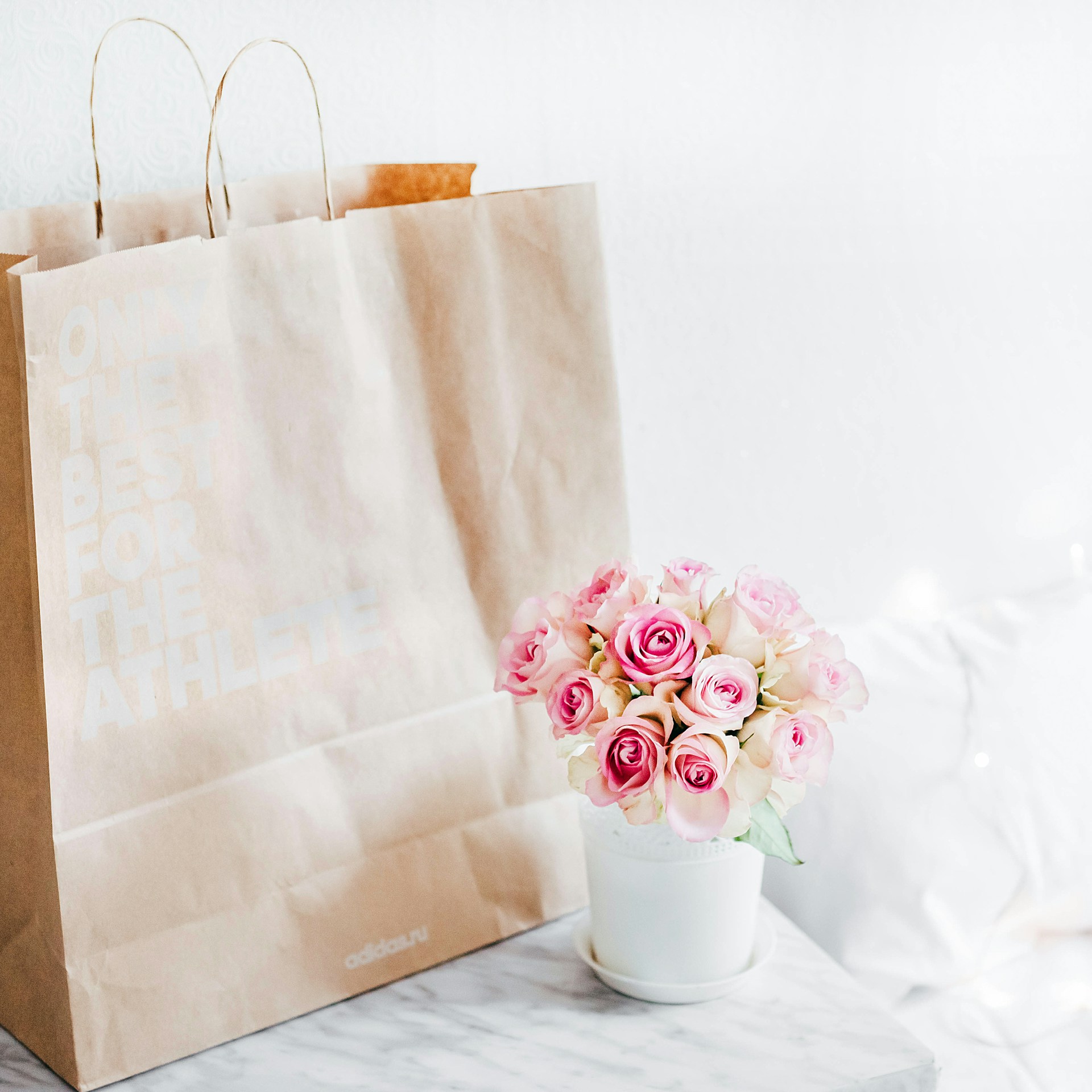 Un sac en papier à côté d'un vase de roses | Source : Unsplash