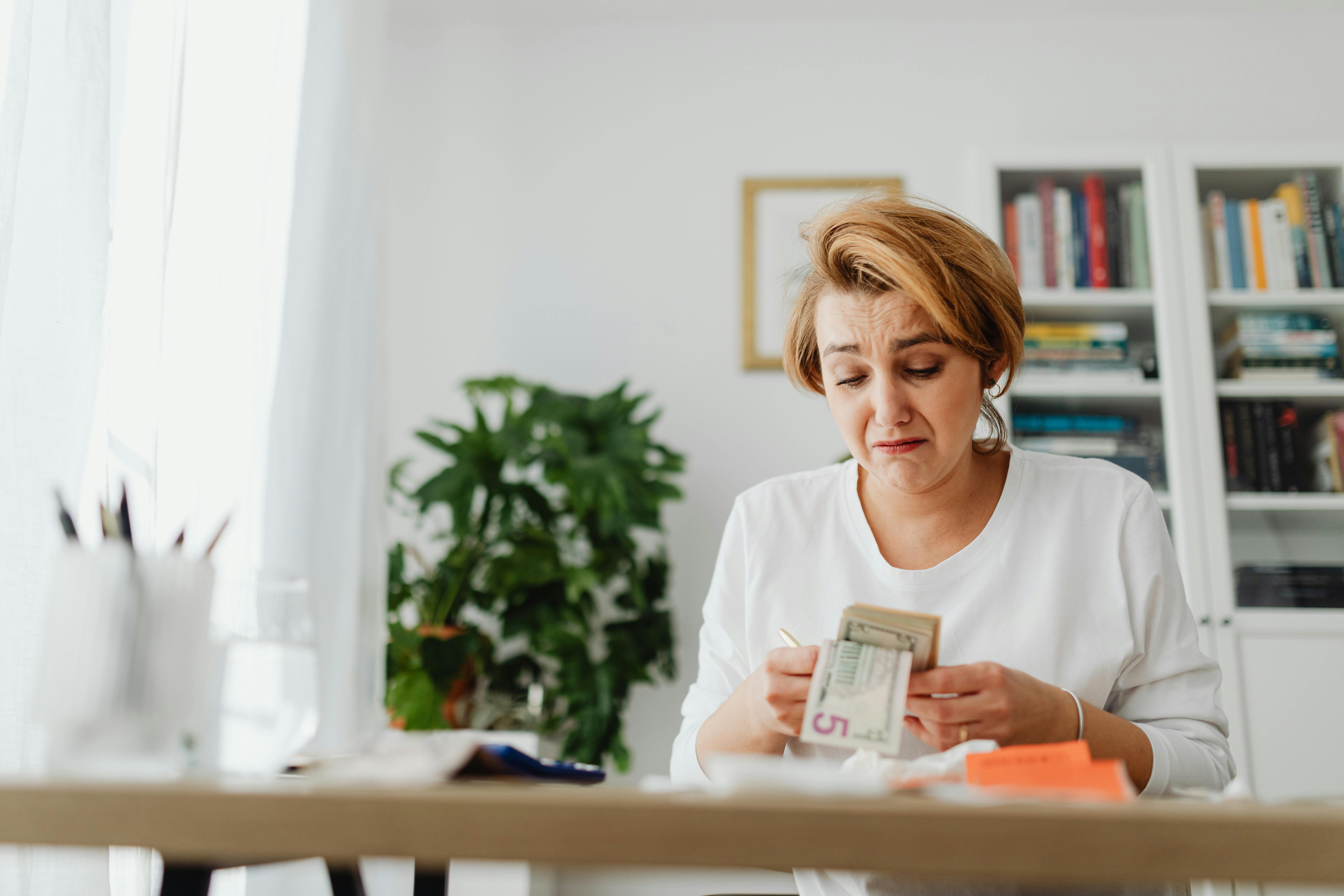 Une femme triste comptant son argent | Source : Pexels