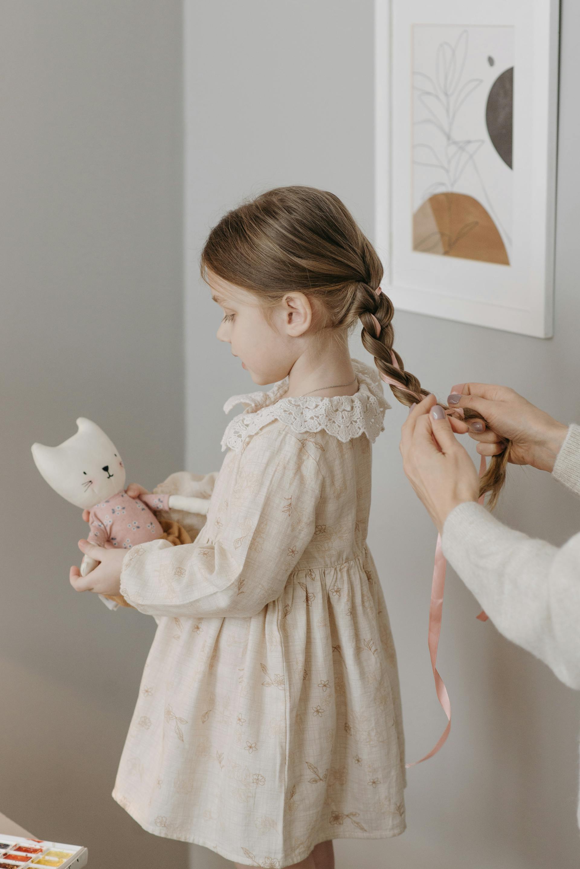 Une femme tressant les cheveux de sa fille | Source : Pexels