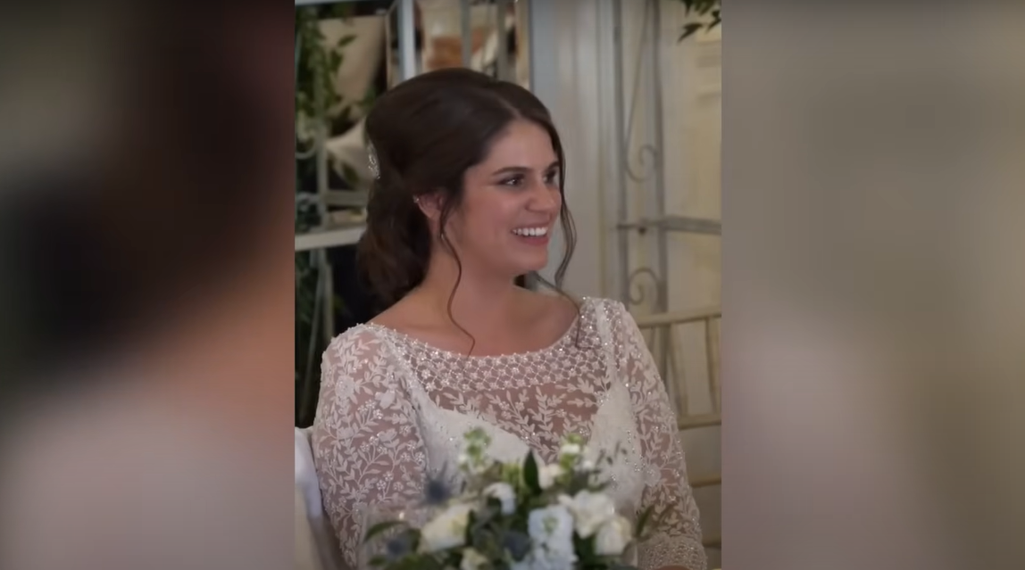 Katie regardant à côté d'elle et souriant | Source : YouTube / Daily Record