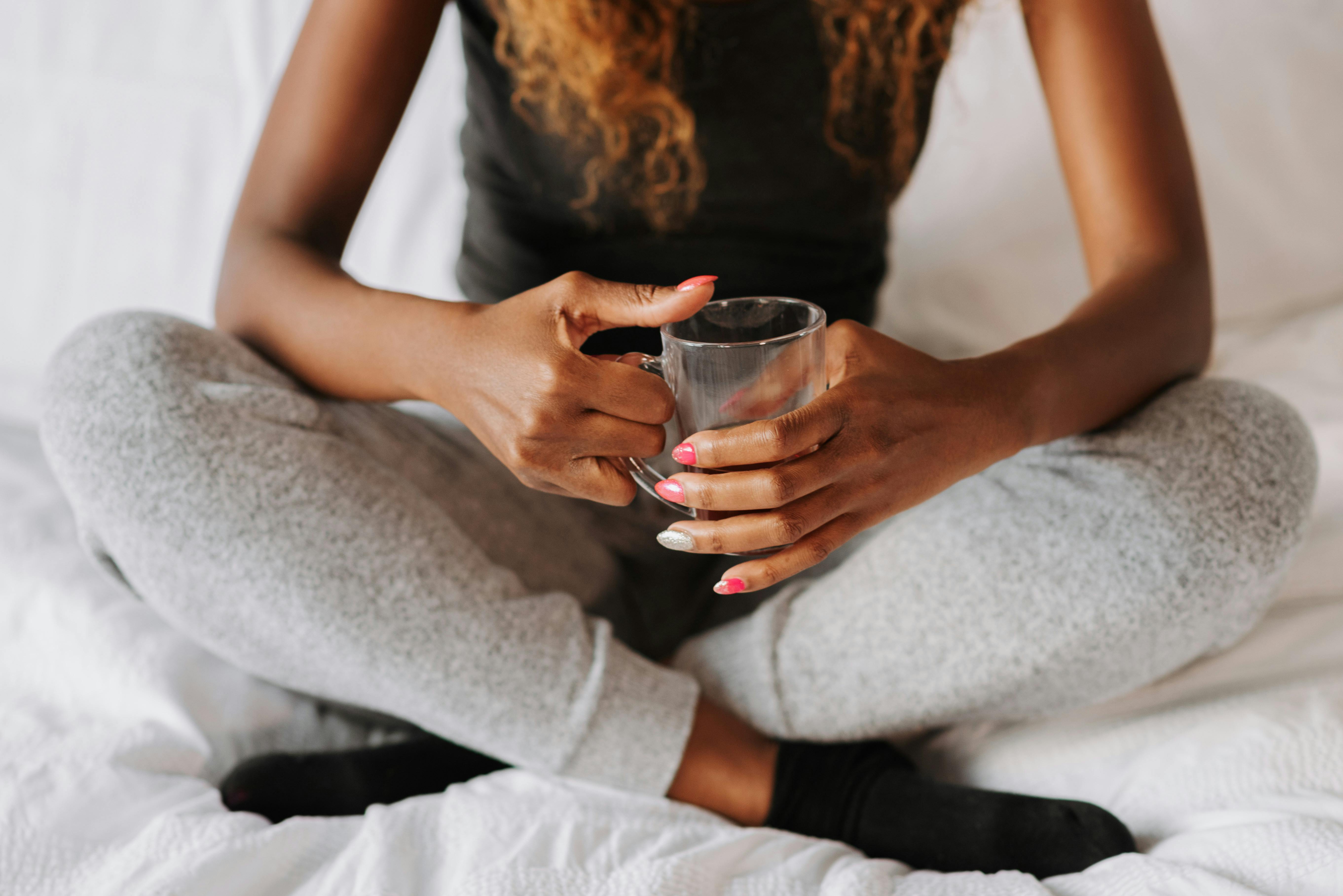 Une femme avec une tasse dans sa chambre | Source : Pexels