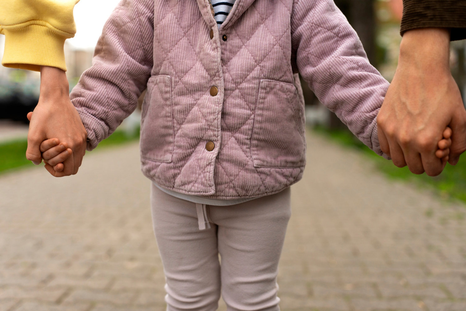 Un enfant tenant la main de ses parents | Source : Freepik