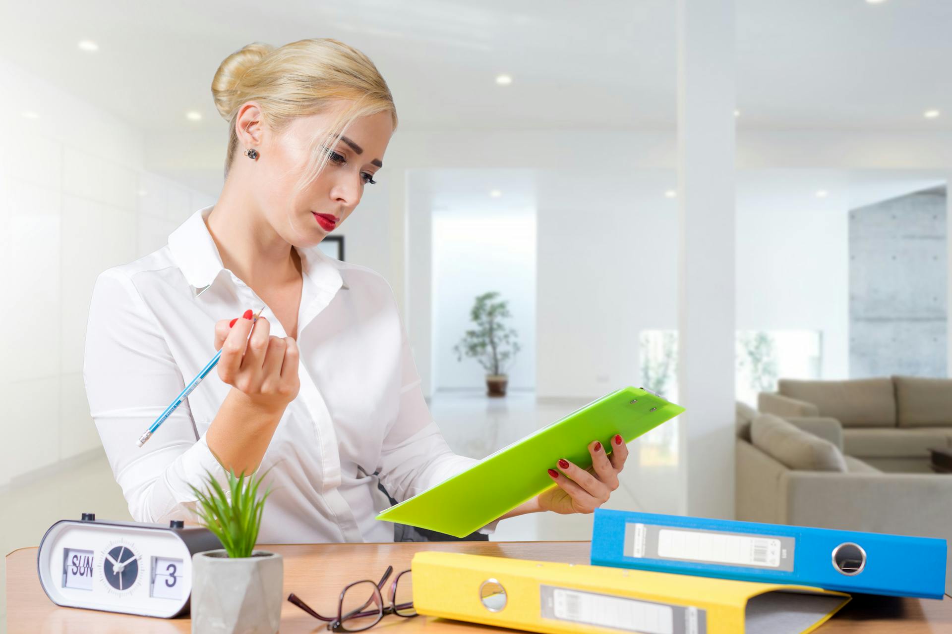 Une réceptionniste regardant un planning en se tenant debout derrière un bureau | Source : Pexels