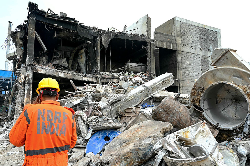 Un secouriste est au téléphone tout en inspectant les décombres de l'usine pharmaceutique de Sigachi Industries, au lendemain d'une explosion survenue à Sangareddy, dans l'État du Telangana, dans le sud de l'Inde, le 1er juillet 2025. | Getty Images