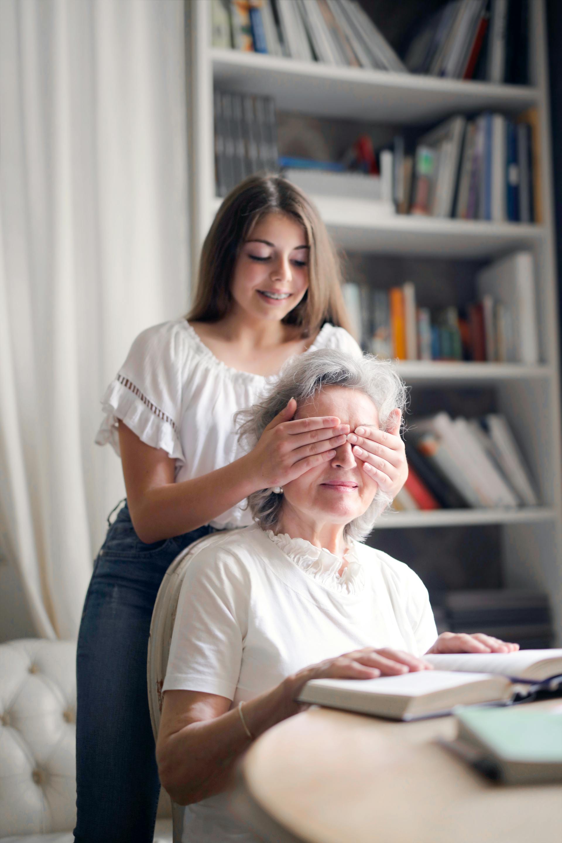 Une petite-fille heureuse jouant au jeu "Devine qui" avec sa grand-mère dans un salon | Source : Pexels