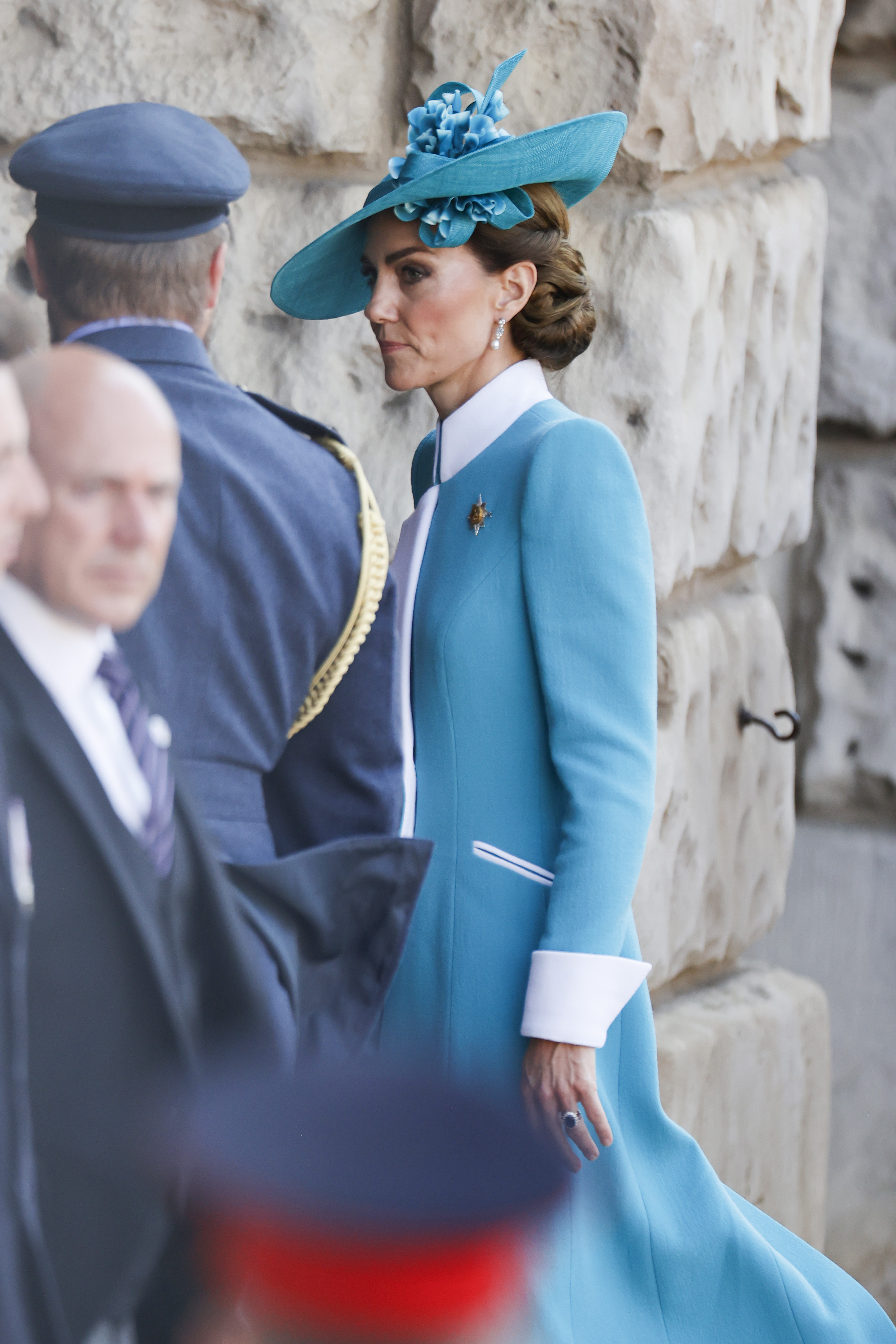 Une photo prise de profil montre en détail la tenue portée par la princesse Catherine lors du Trooping the Colour 2025. Son manteau bleu sarcelle sur mesure, rehaussé de poignets et d'un col blancs audacieux, est complété par un chapeau assorti orné de fleurs. L'angle met en valeur les lignes raffinées de sa tenue et l'élégance de sa posture alors qu'elle participe à la cérémonie.