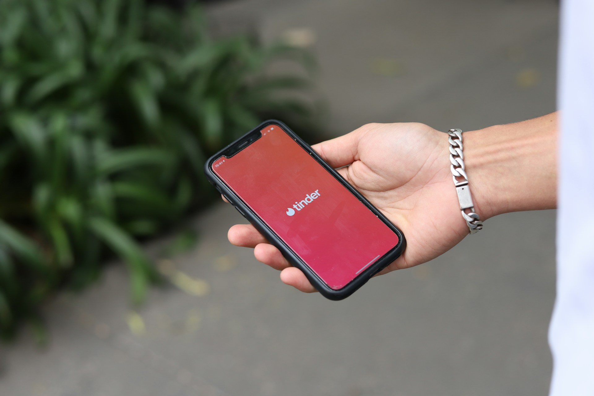 Un homme tenant un téléphone portable affichant l'application Tinder | Source : Unsplash