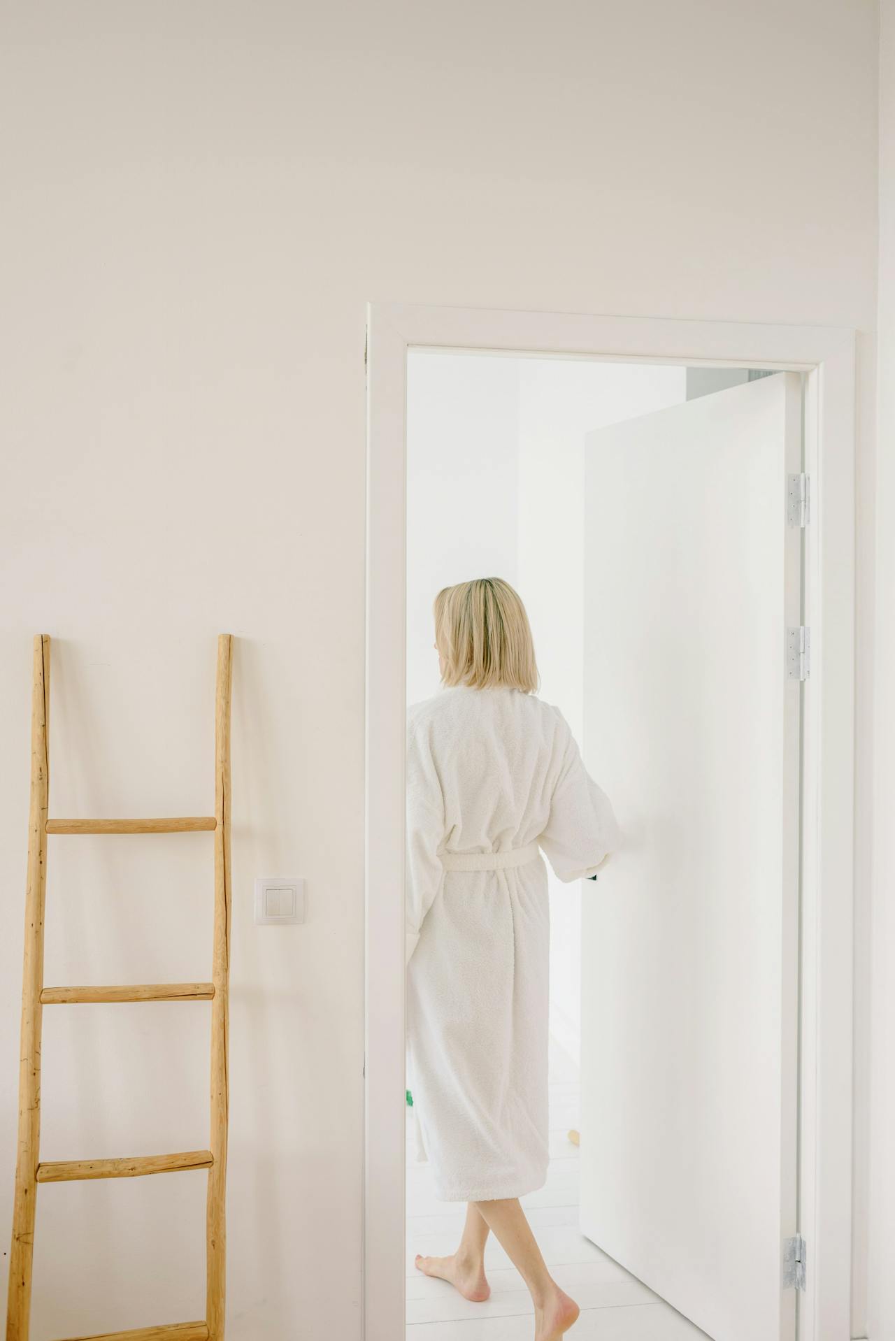 Une femme en peignoir se tenant à l'entrée de la porte | Source : Pexels