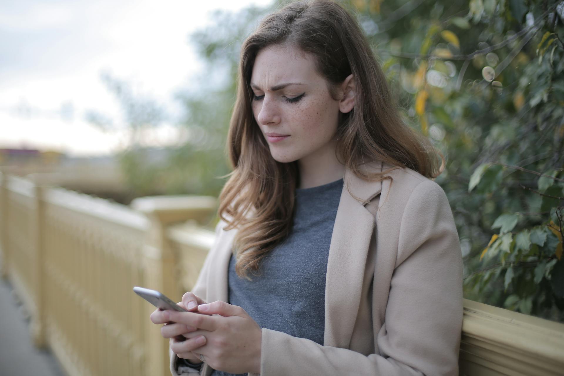 Une femme fronce les sourcils en regardant son téléphone | Source : Pexels