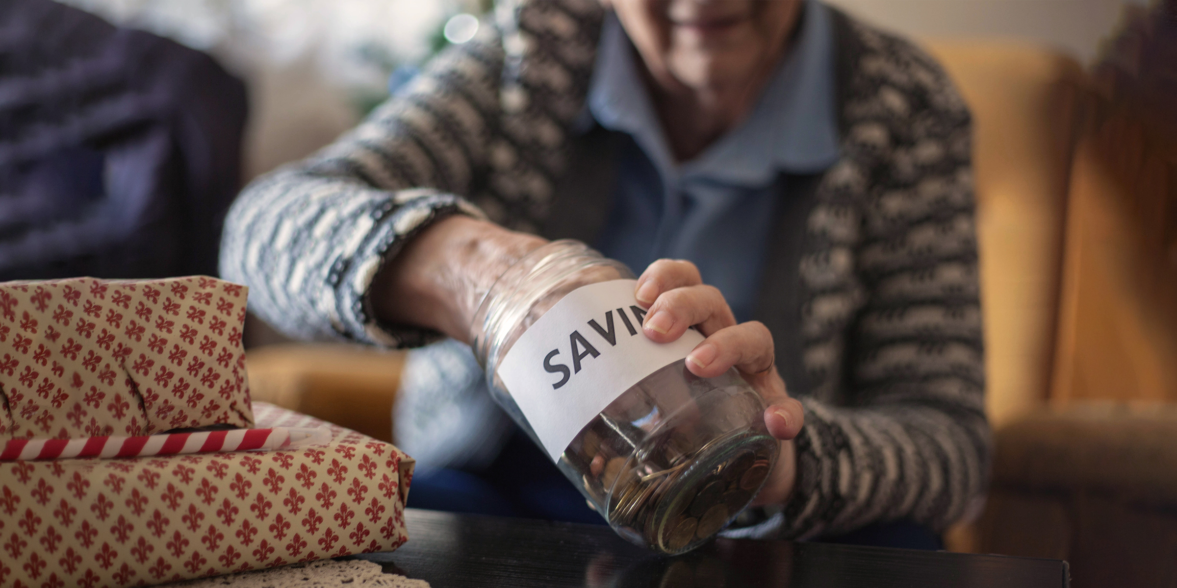 Une femme âgée plongeant sa main dans son pot d'épargne | Source : Shutterstock