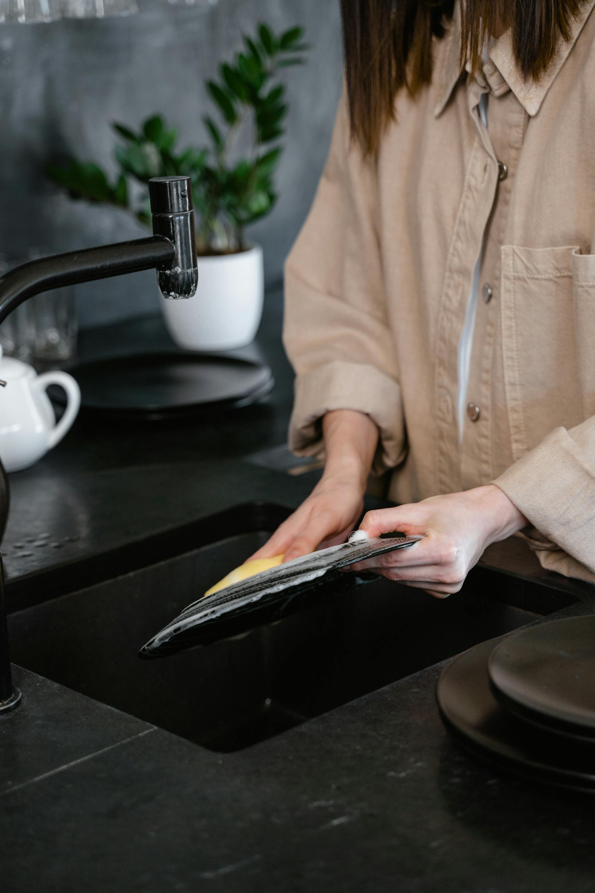 Une femme lave une assiette | Source : Pexels