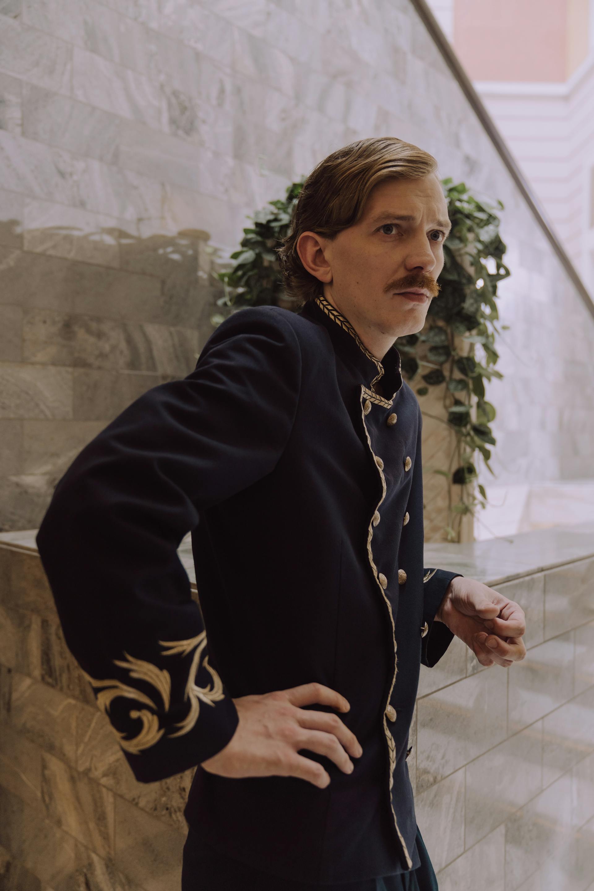 Un homme en uniforme de concierge d'hôtel à l'expression sérieuse | Source : Pexels
