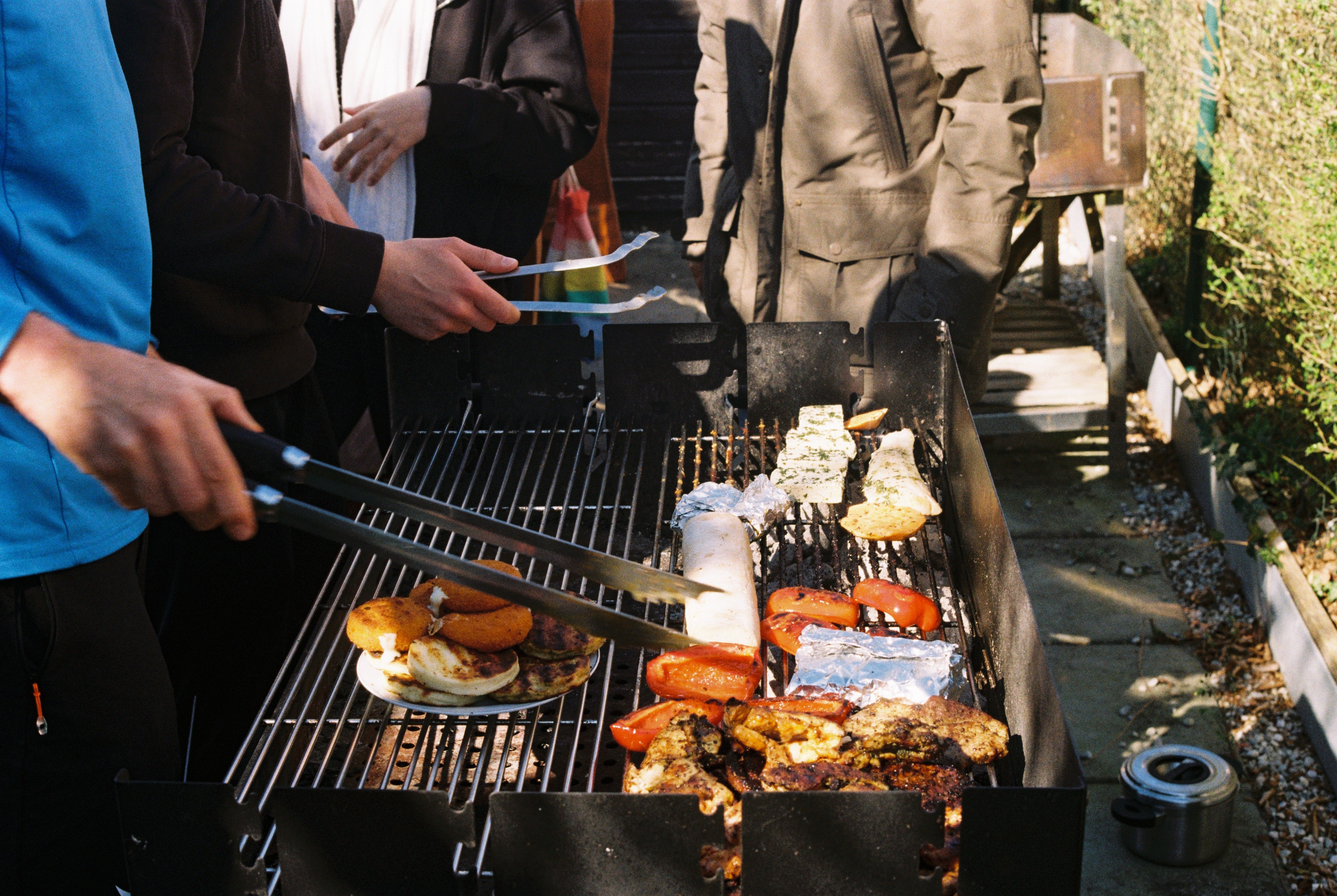 Des hommes qui font cuire toutes sortes d'aliments au barbecue en plein air lors d'une soirée barbecue | Source : Pexels