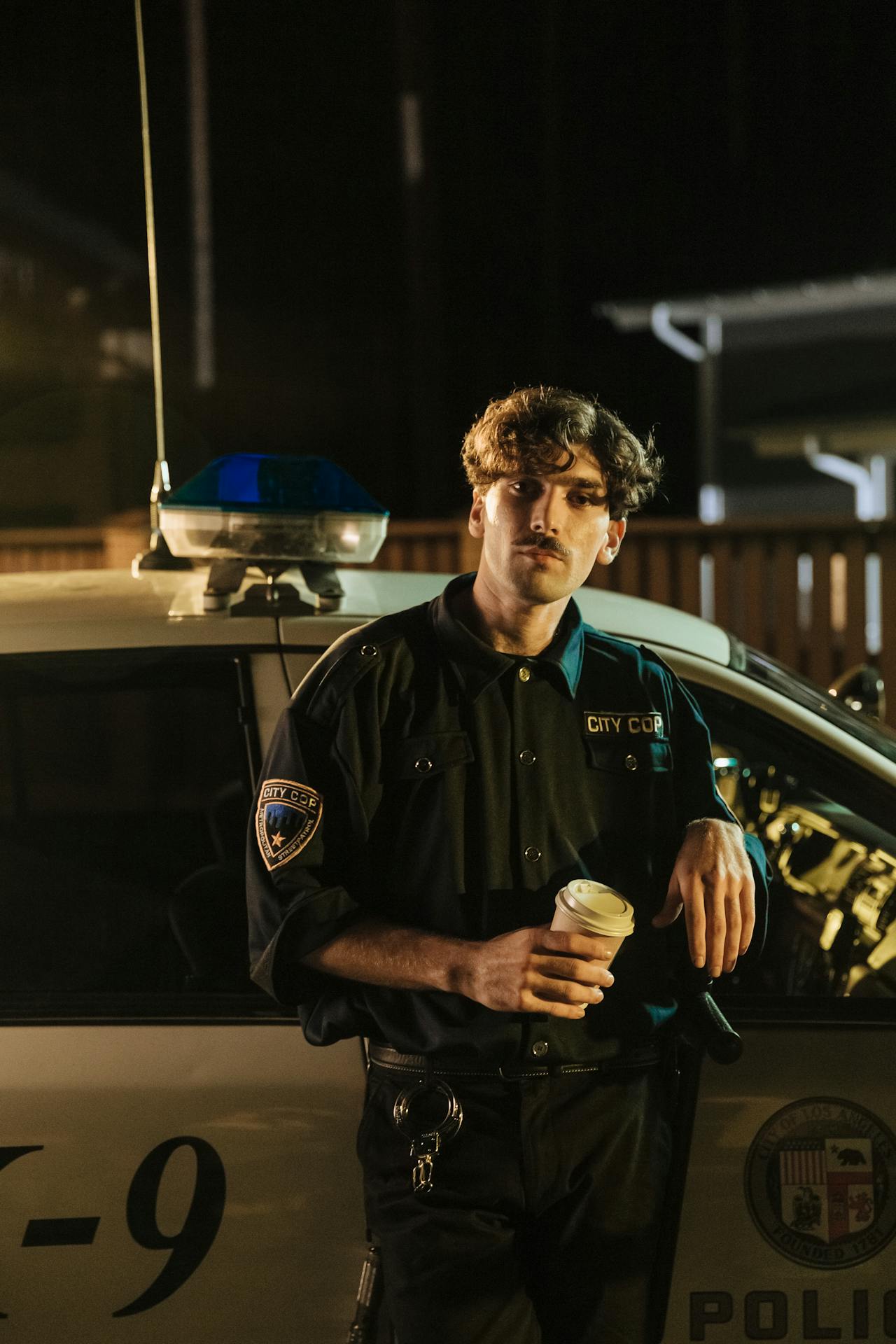 Un policier se tenant devant une voiture de police | Source : Pexels