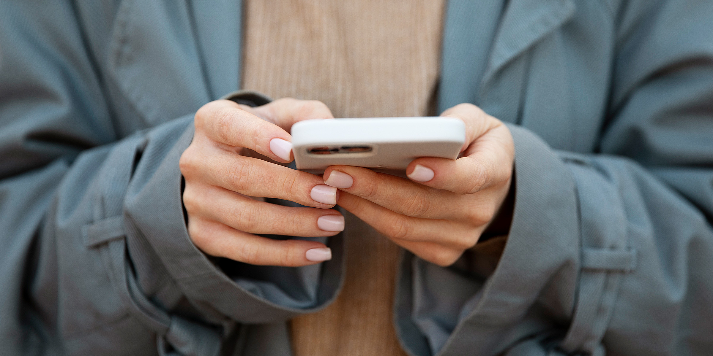 Une femme tenant son téléphone | Source : Freepik