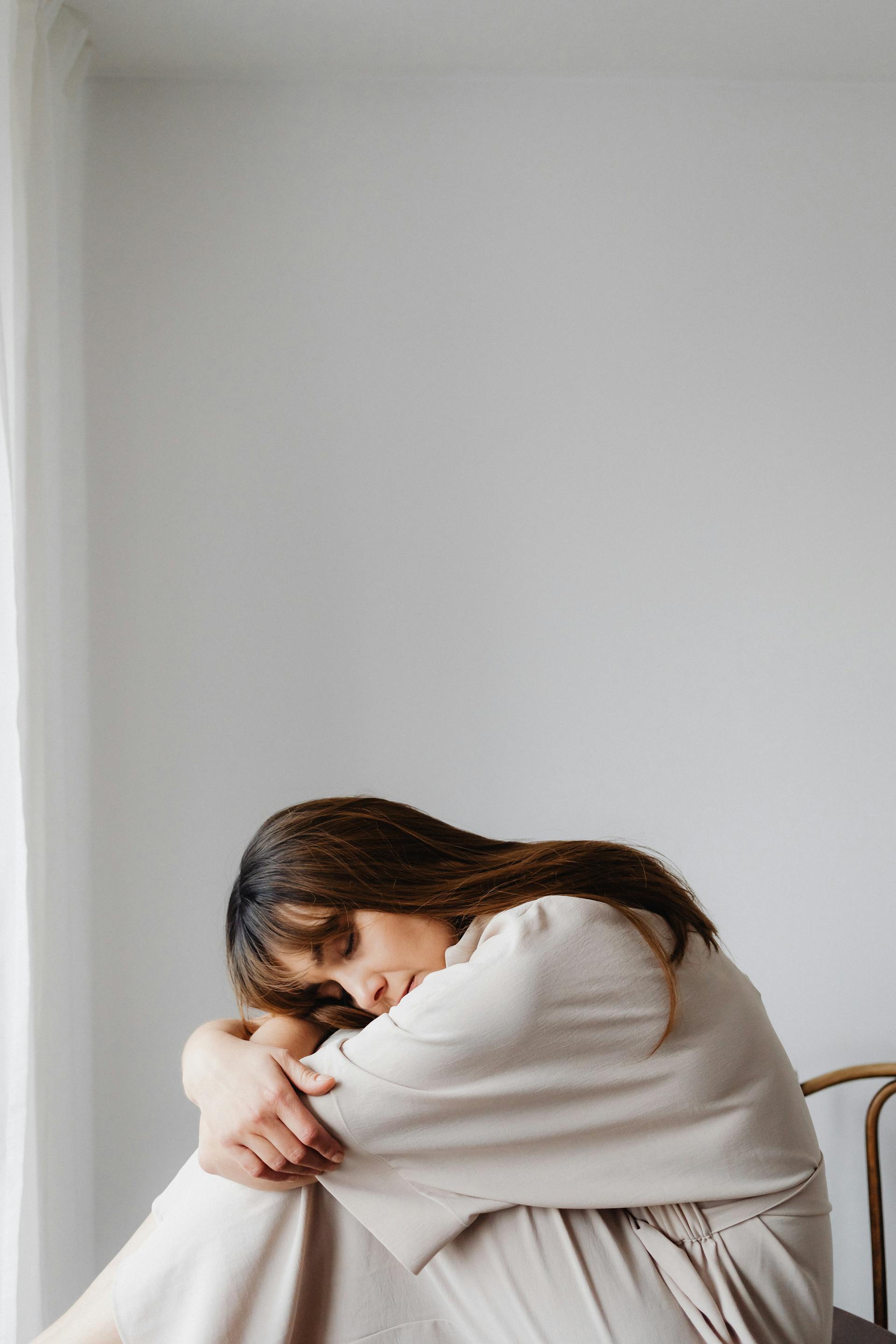 Une femme fatiguée assise dans une position voûtée | Source : Pexels