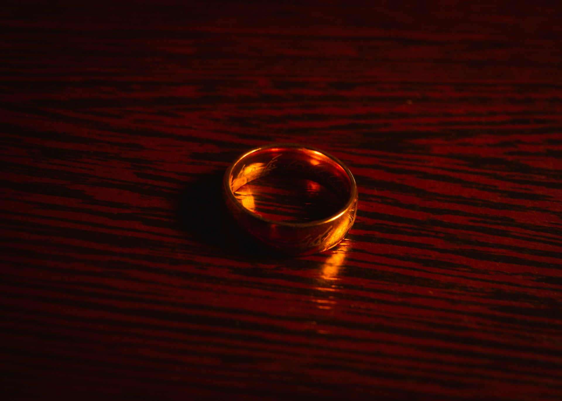 Gros plan d'une bague en or sur une surface en bois brun | Source : Unsplash
