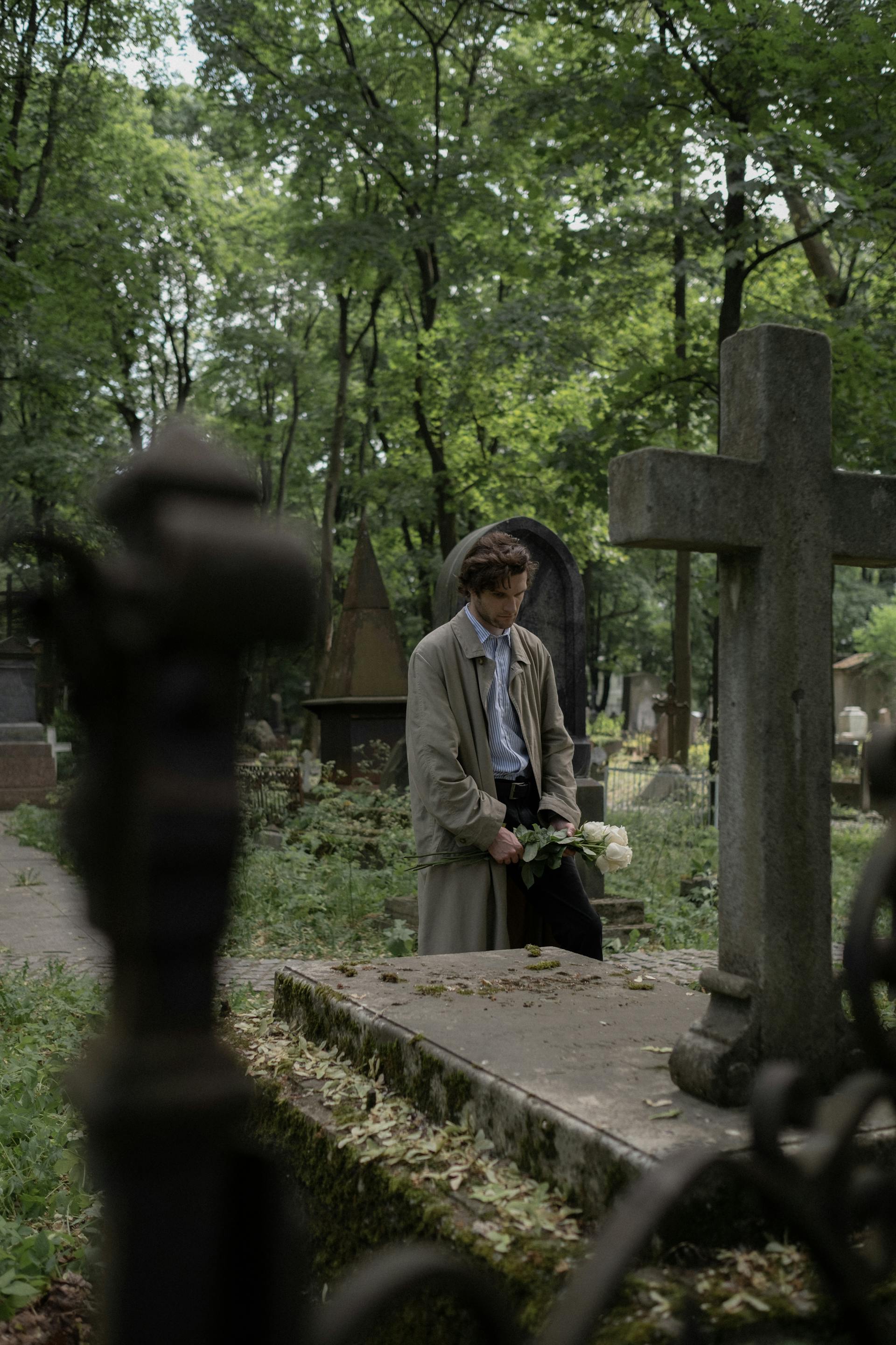 Un homme debout devant la tombe d'un être cher dans un cimetière | Source : Pexels