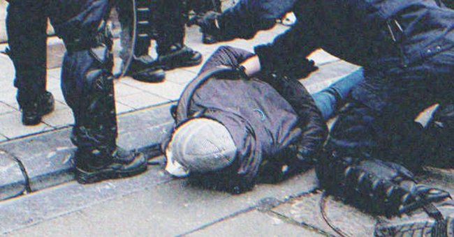 Des policiers qui arrêtent un sans-abri | Source : Shutterstock.com