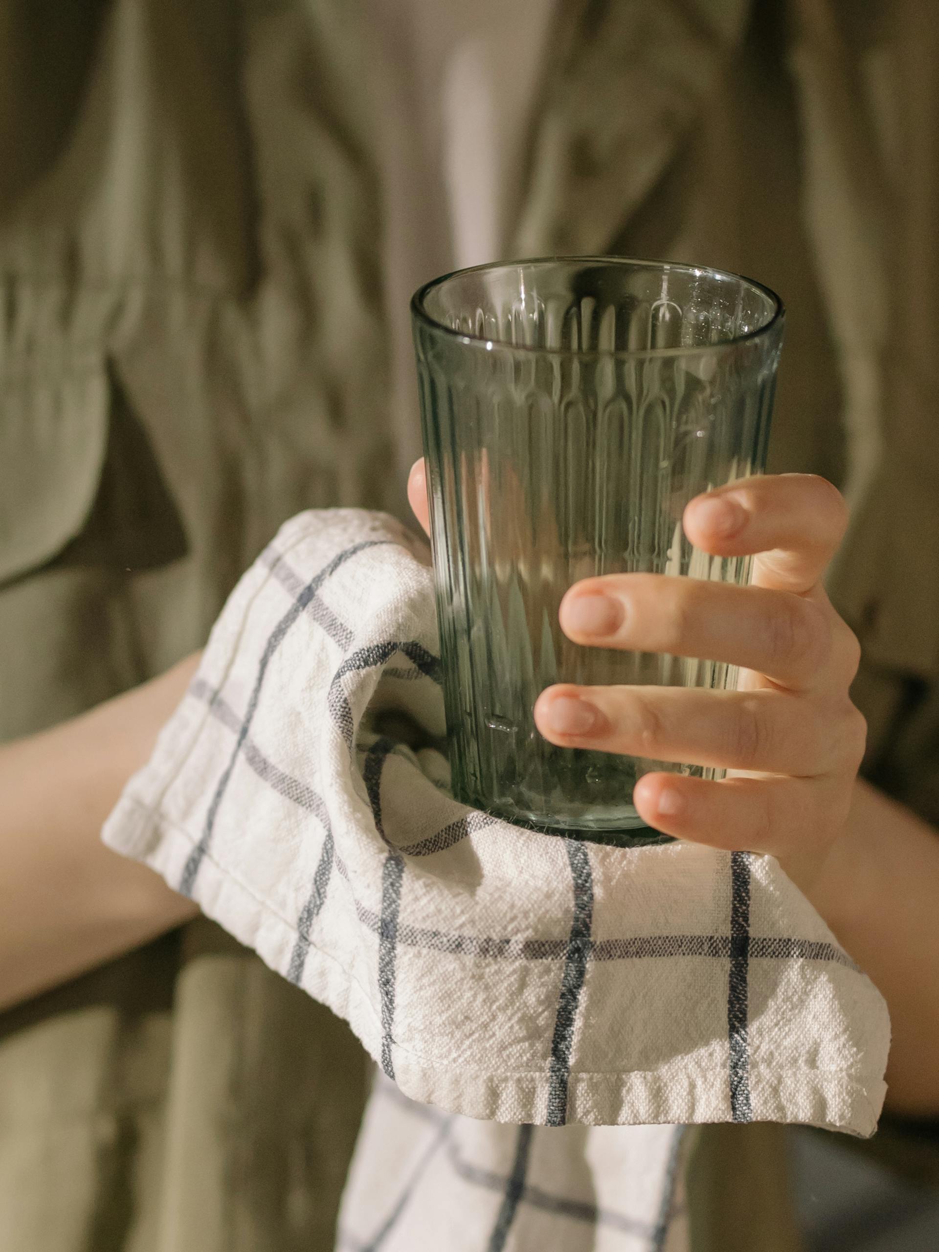 Une femme essuie un verre avec un torchon | Source : Pexels