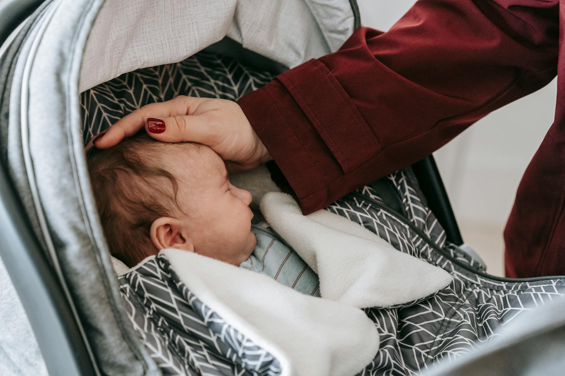 Une mère admirant son bébé endormi dans la poussette | Source : Pexels