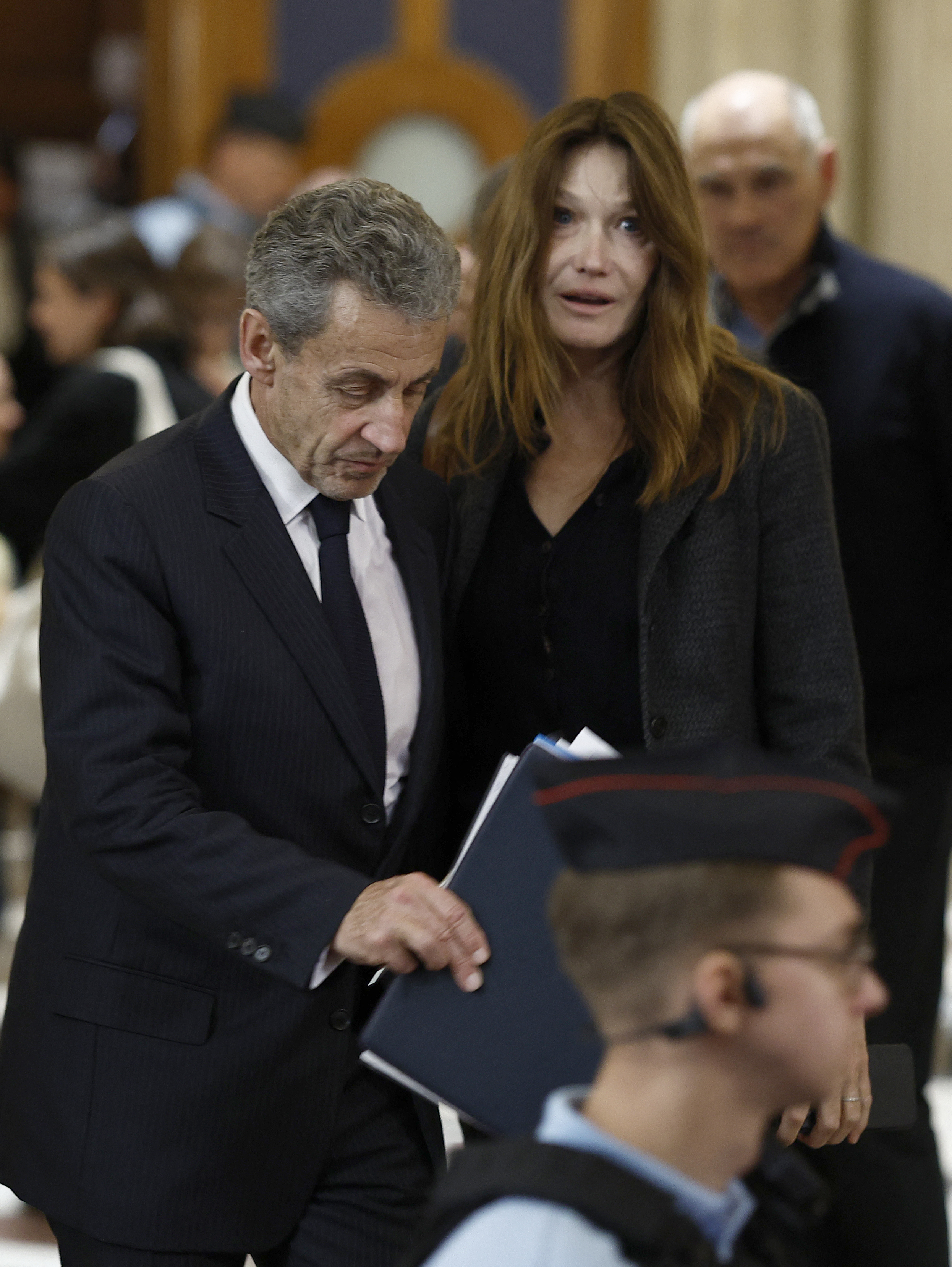 L'ancien président français Nicolas Sarkozy (à gauche) et son épouse Carla Bruni-Sarkozy quittent la salle d'audience après une suspension d'audience lors de son procès en appel concernant les accusations selon lesquelles il aurait sollicité un financement libyen pour sa campagne électorale de 2007, au Palais de Justice de Paris, le 7 avril 2026 I Source : Getty Images