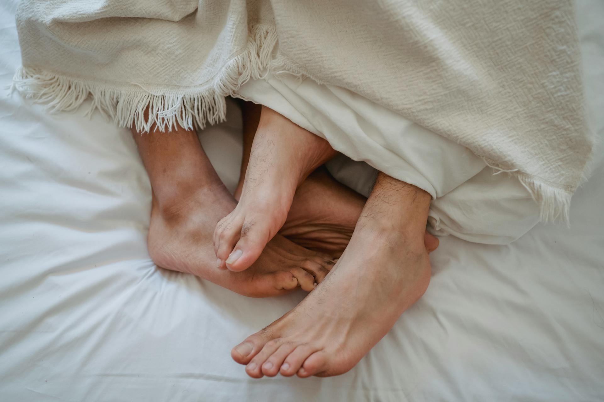 Deux hommes entrelacés dans un lit | Source : Pexels