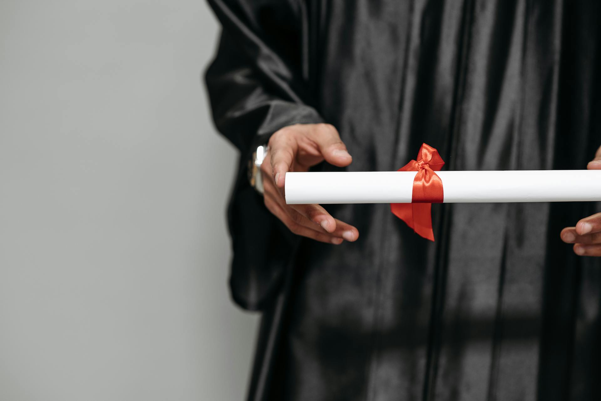 Une personne tendant un diplôme | Source : Pexels