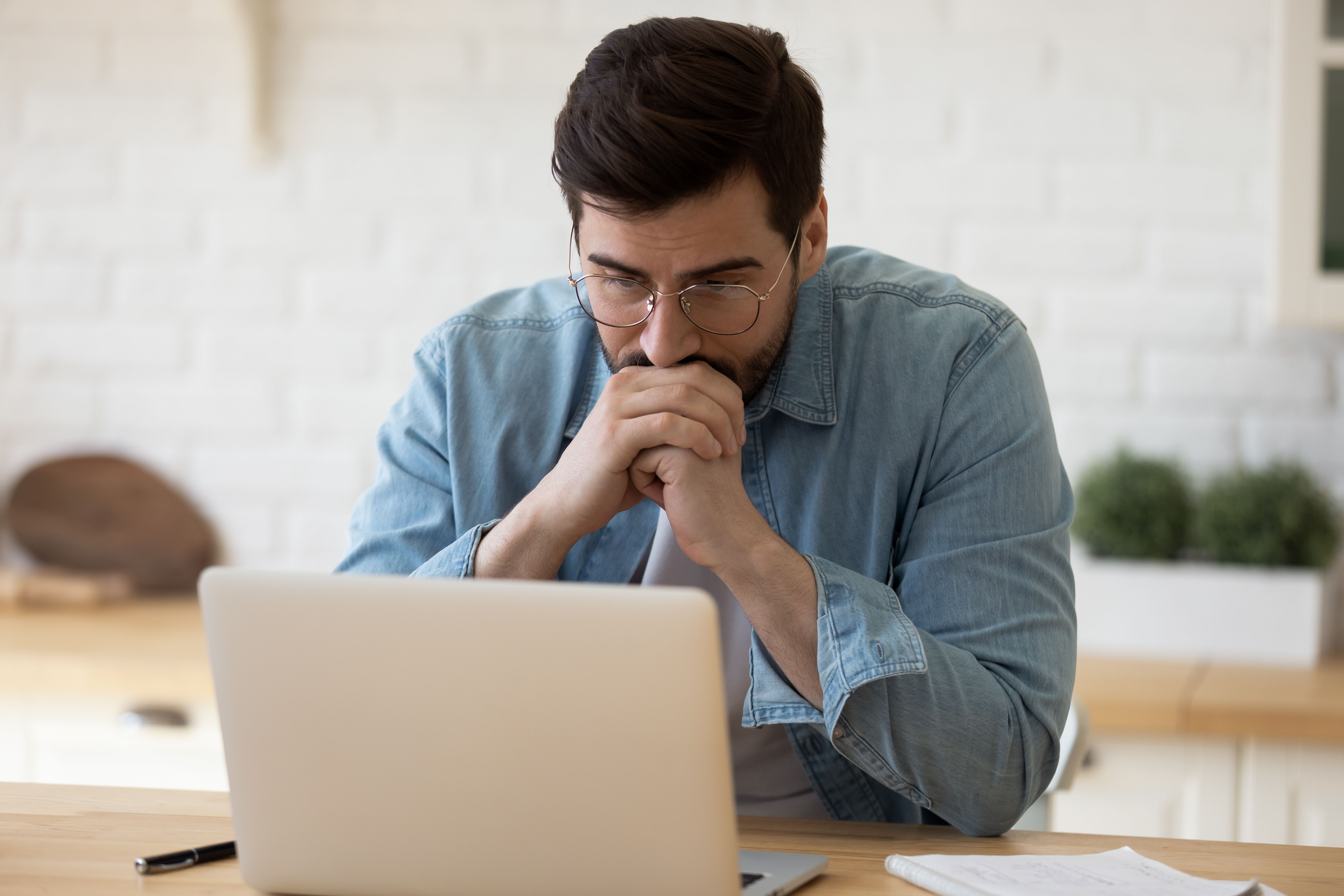 Un homme fixant son ordinateur | Source : Shutterstock