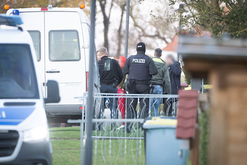 Des enquêteurs perquisitionnent des maisons pendant l'enquête | Source : Getty Images